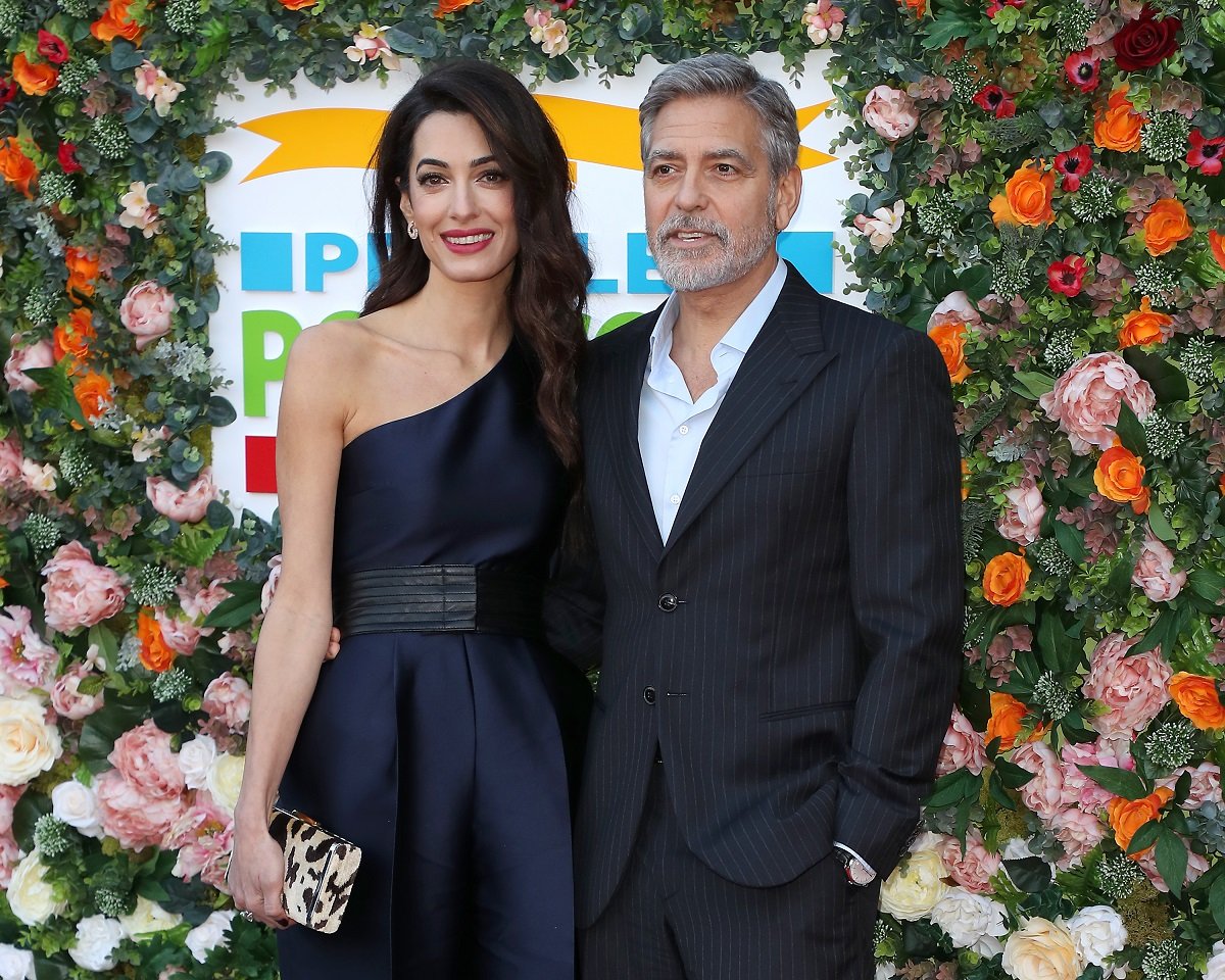 George Clooney and Amal Clooney, who have luxury homes across the globe, smile for a photo at the People's Postcode Lottery Charity Gala