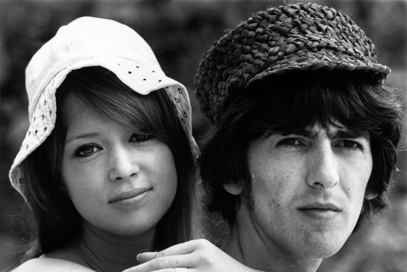 A black and white picture of Pattie Boyd and George Harrison wearing hats.