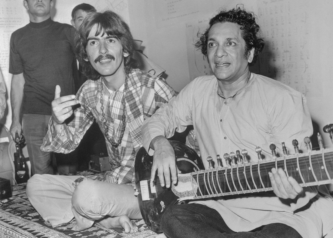 George Harrison and Ravi Shankar playing Indian music together on the floor in 1967.