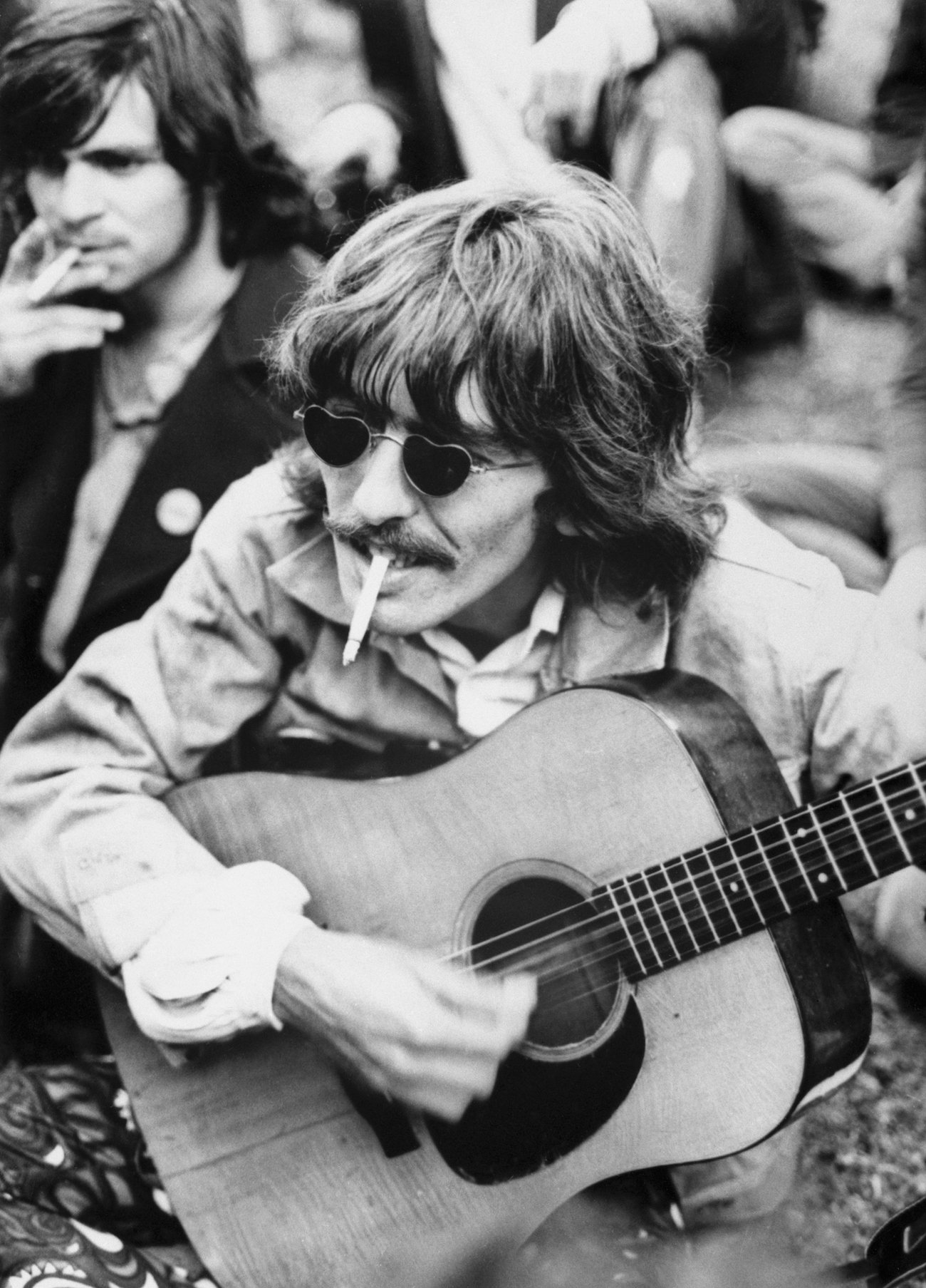 George Harrison playing guitar for fans at Haight-Ashbury in 1967.
