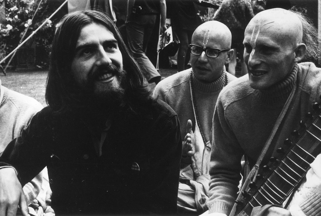 George Harrison wearing black with members of the Hare Krishna temple in 1969.