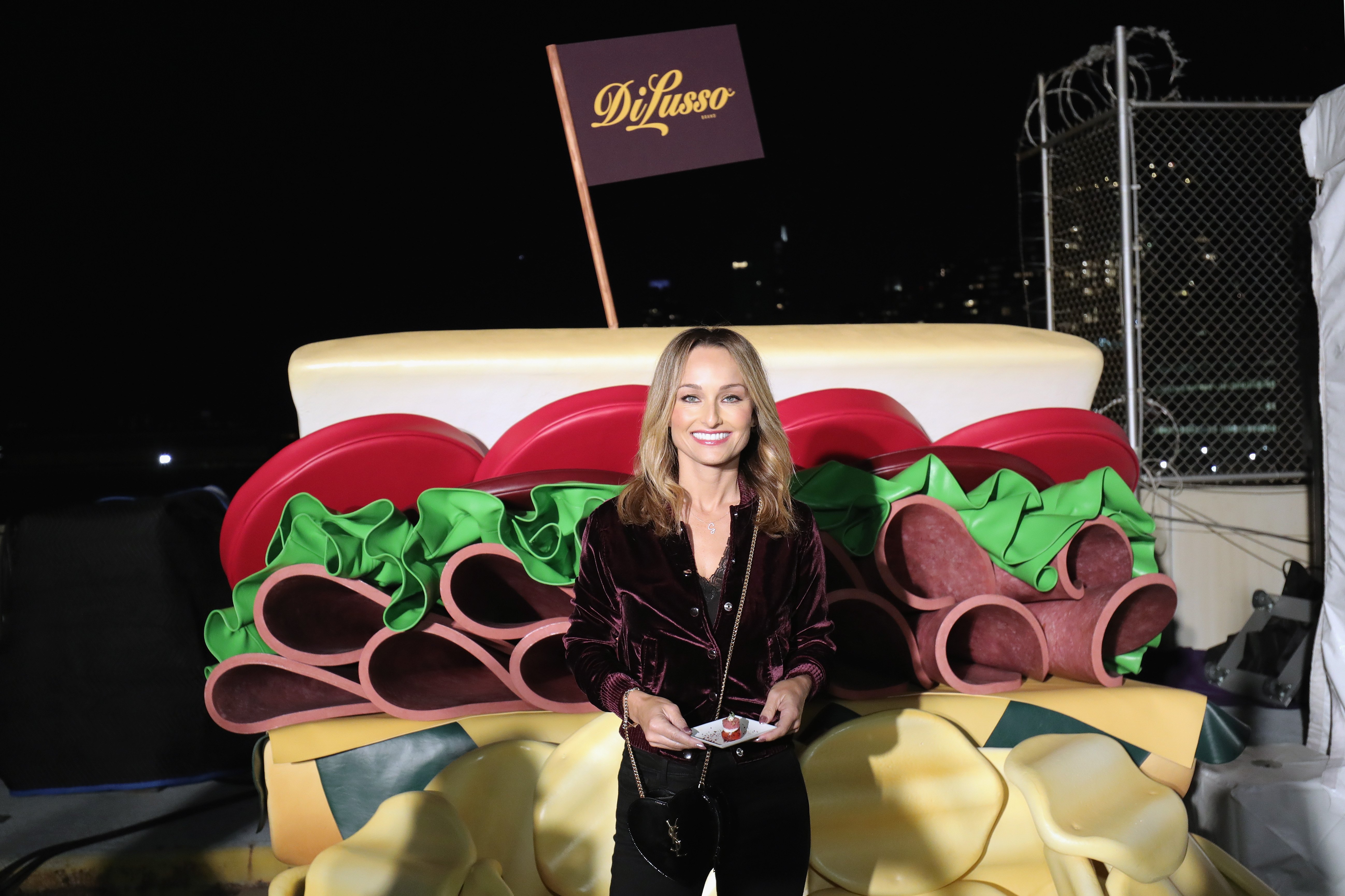 Food Network host Giada De Laurentiis wears a purple blouse in this photograph.