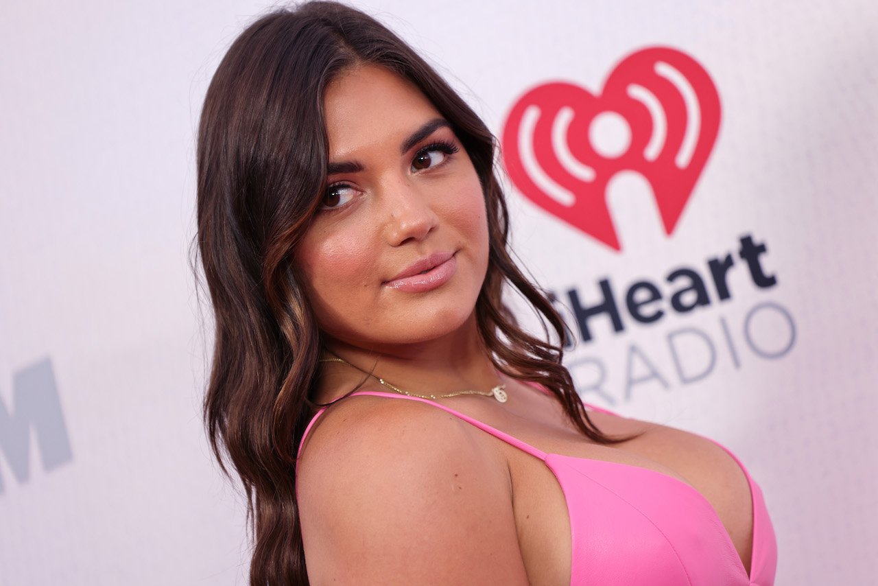 Giannina Gibelli looks over her shoulder in a pink dress.