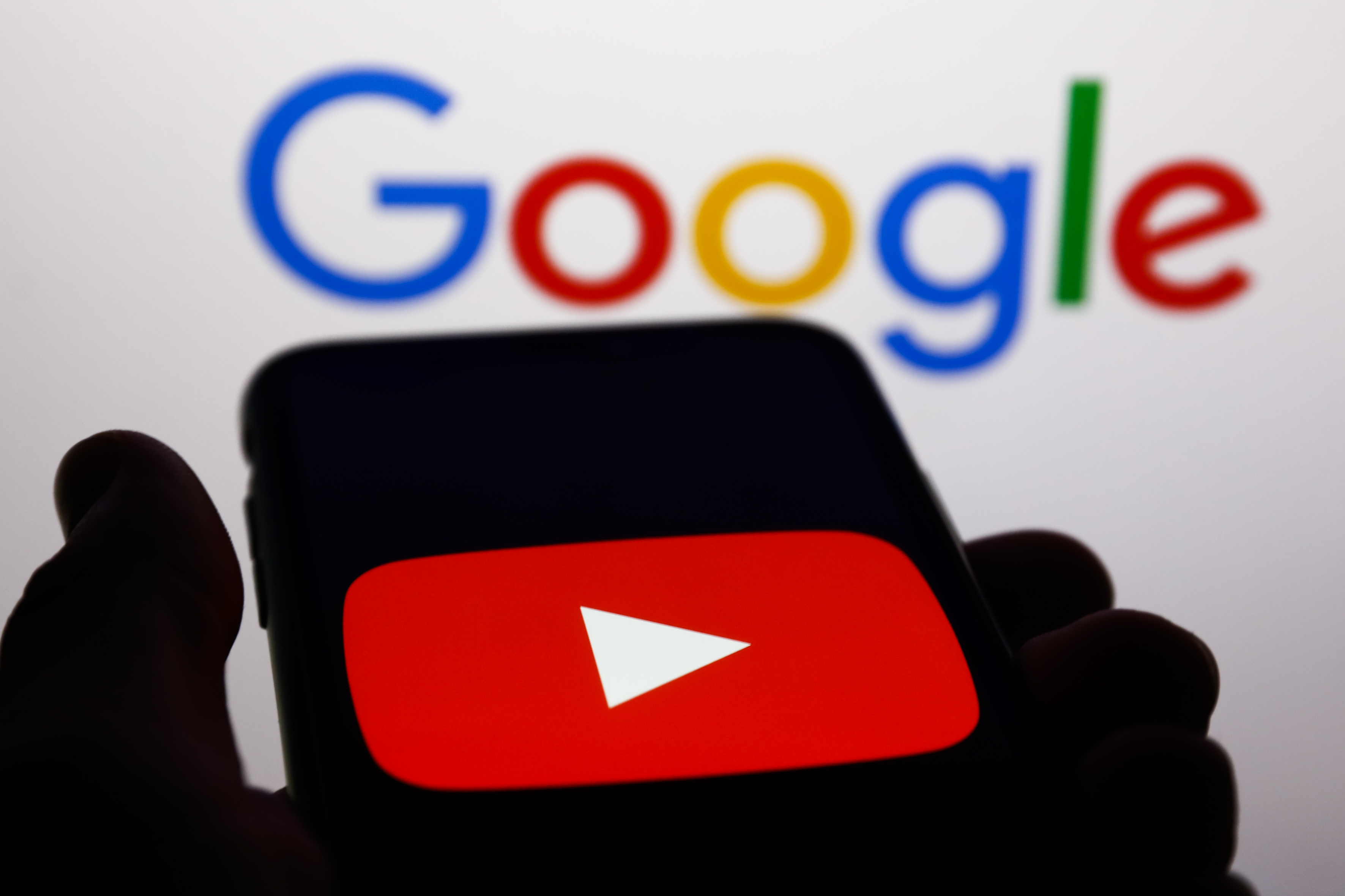 YouTube logo displayed on a phone screen and Google logo displayed on a screen