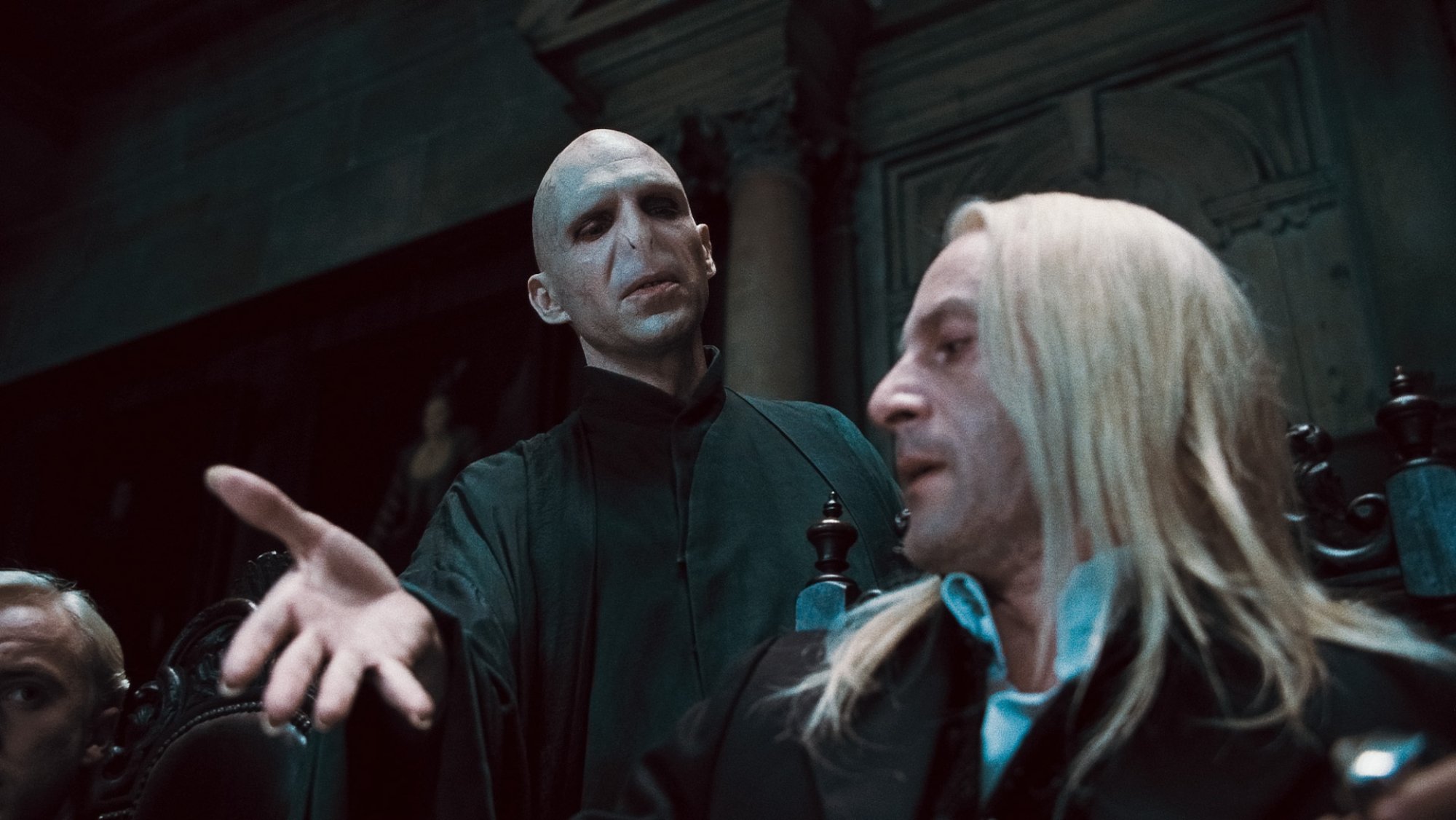 'Harry Potter' Tom Felton as Draco Malfoy, Ralph Fiennes as Voldemort, and Jason Isaacs as Lucius Malfoy near extravagant-looking chairs with Voldemort holding his hand out