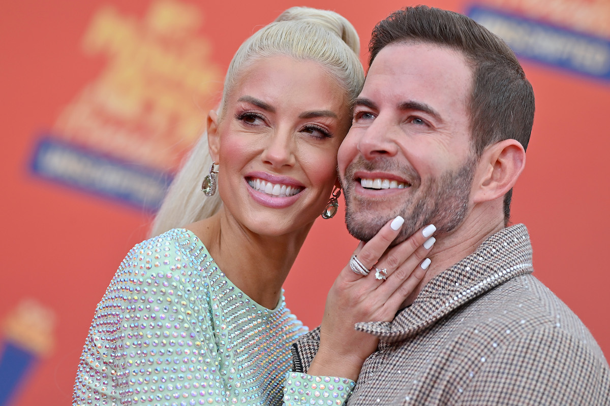 Heather Rae Young and Tarek El Moussa smile and pose at an event.