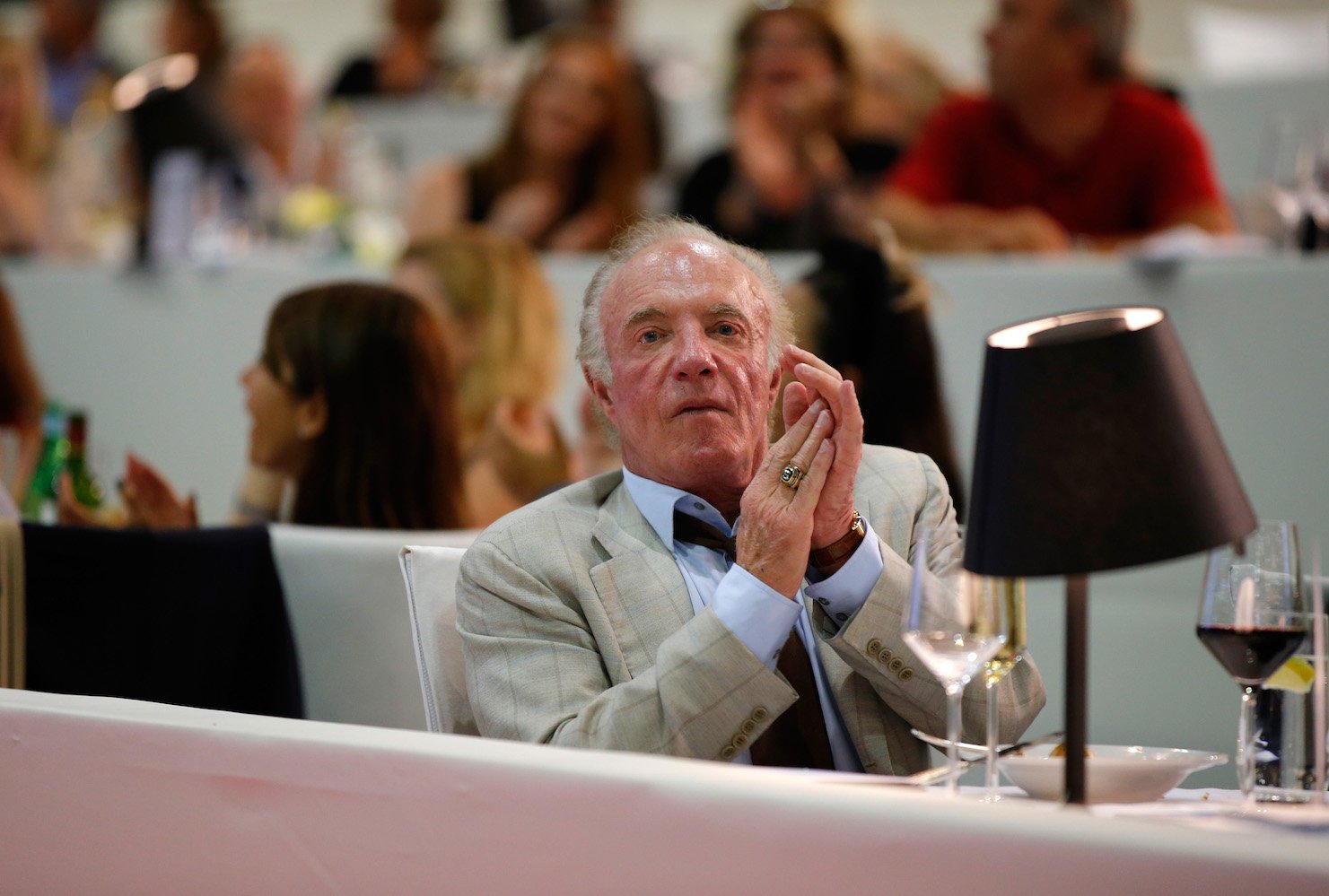 James Caan sitting at a table and clapping