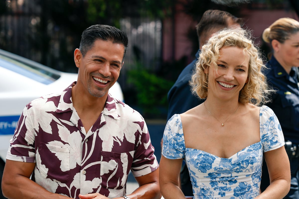 Smiling photo of Jay Hernandez and Perdita Weeks, both wearing Hawaiian shirts, in an episode of 'Magnum P.I.'