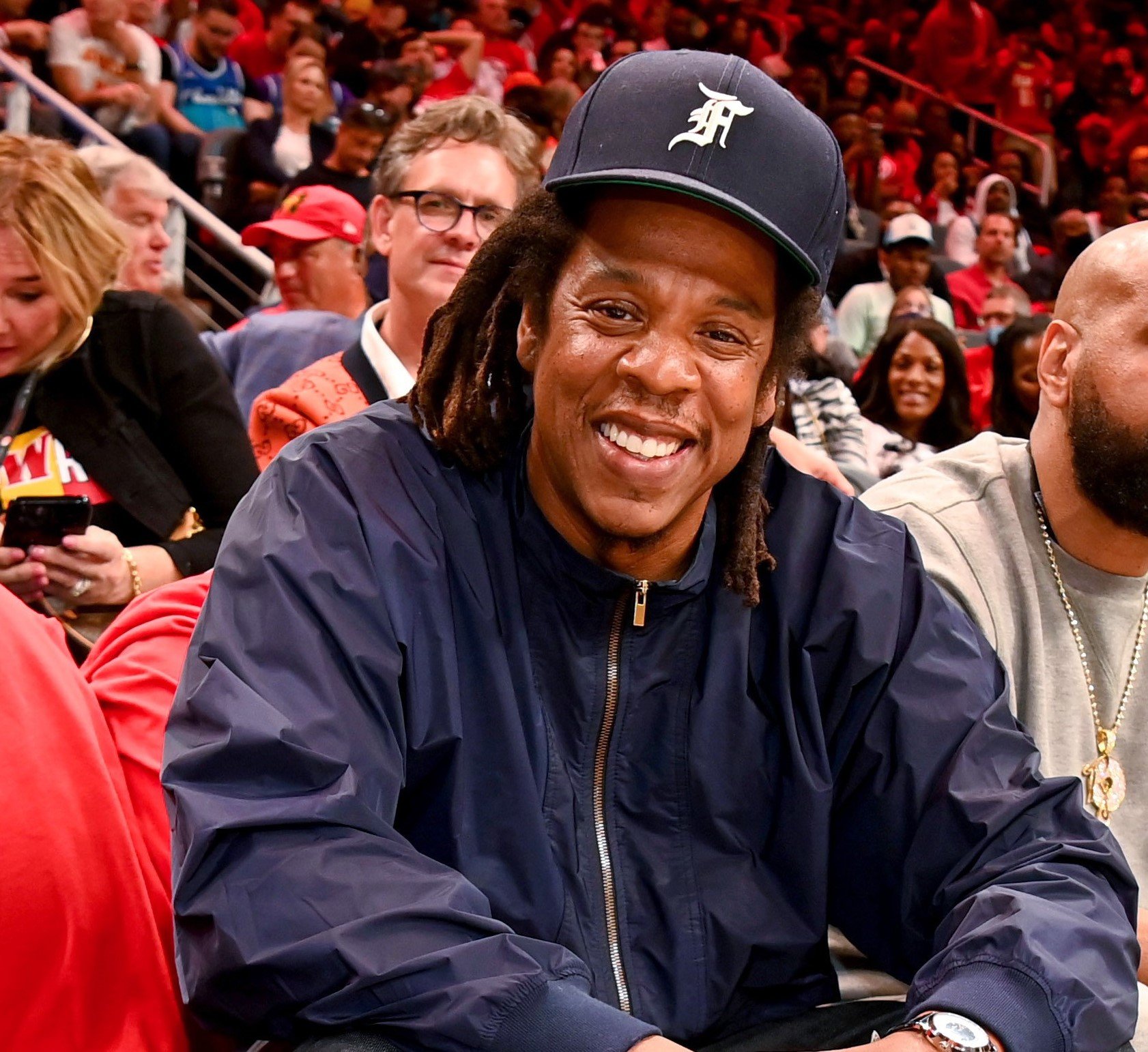 Jay-Z, who is not on social media, smiling at an NBA game between the Charlotte Hornets and Atlanta Hawks
