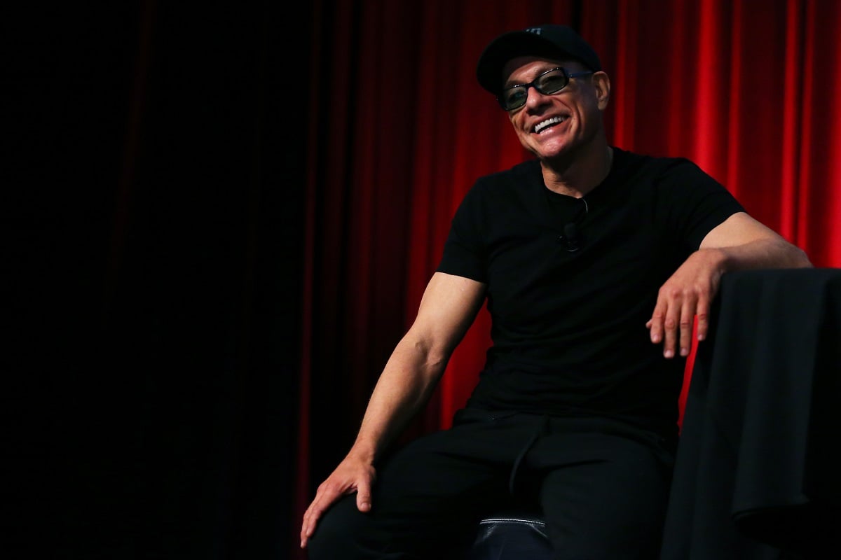 Jean-Claude Van Damme smiling while wearing a black shirt.