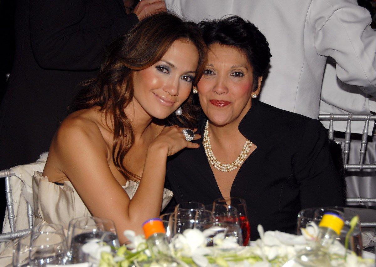 Jennifer Lopez and her mom, Guadalupe Rodriguez, sit and smile together at an event.