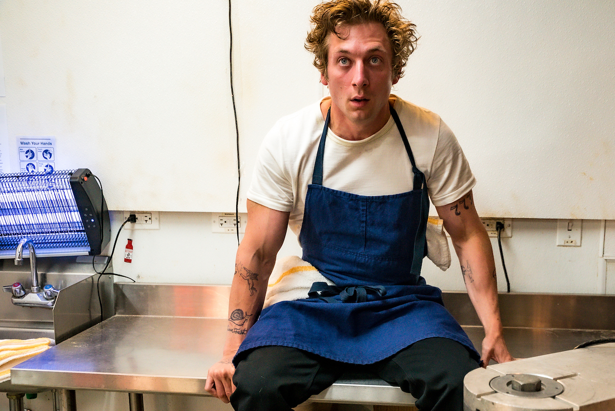 Jeremy Allen White, as Carmy who speaks 'The Bear' kitchen jargon in the FX series, sits on a counter