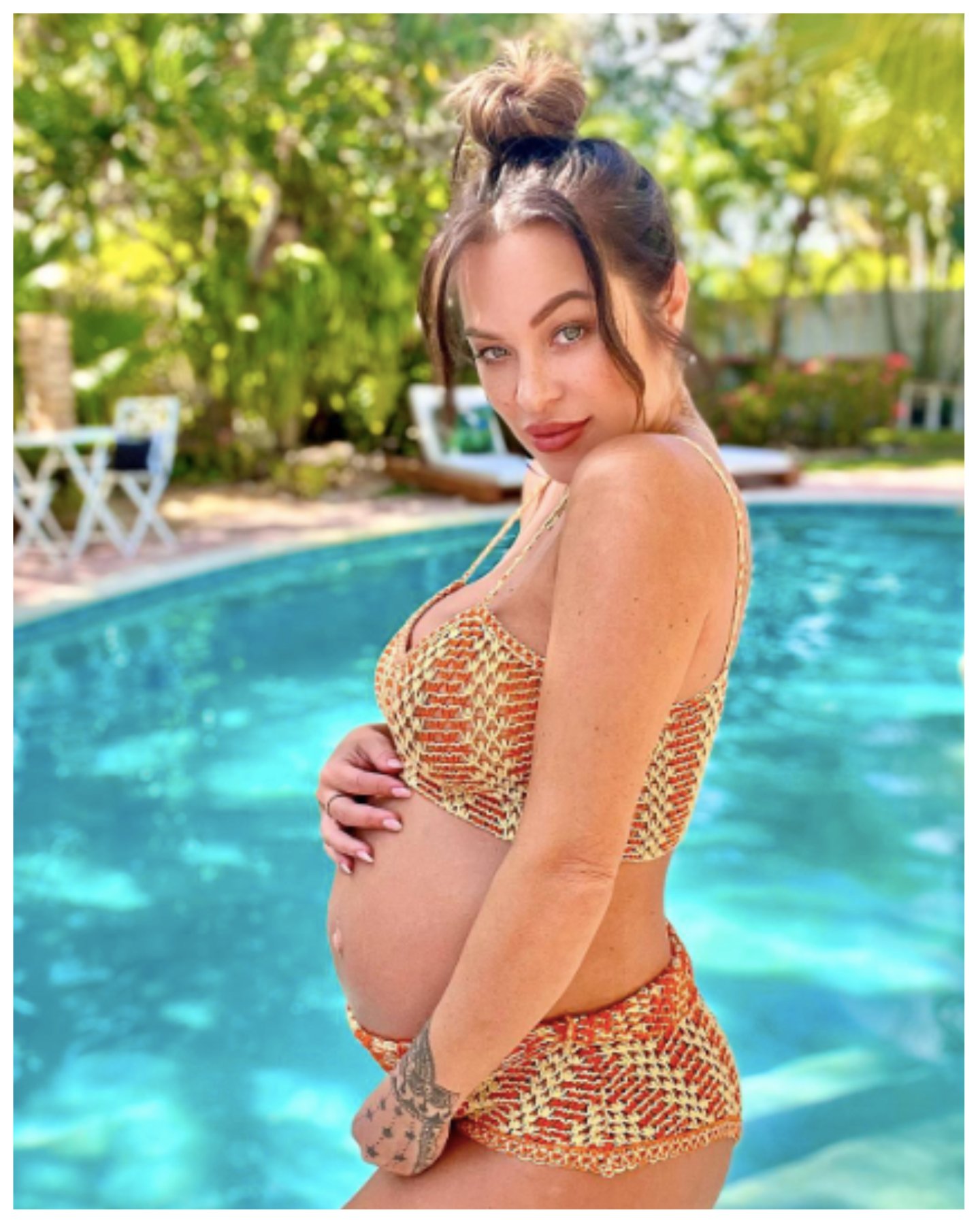 Jessica More wears a swimsuit and holds her pregnant belly