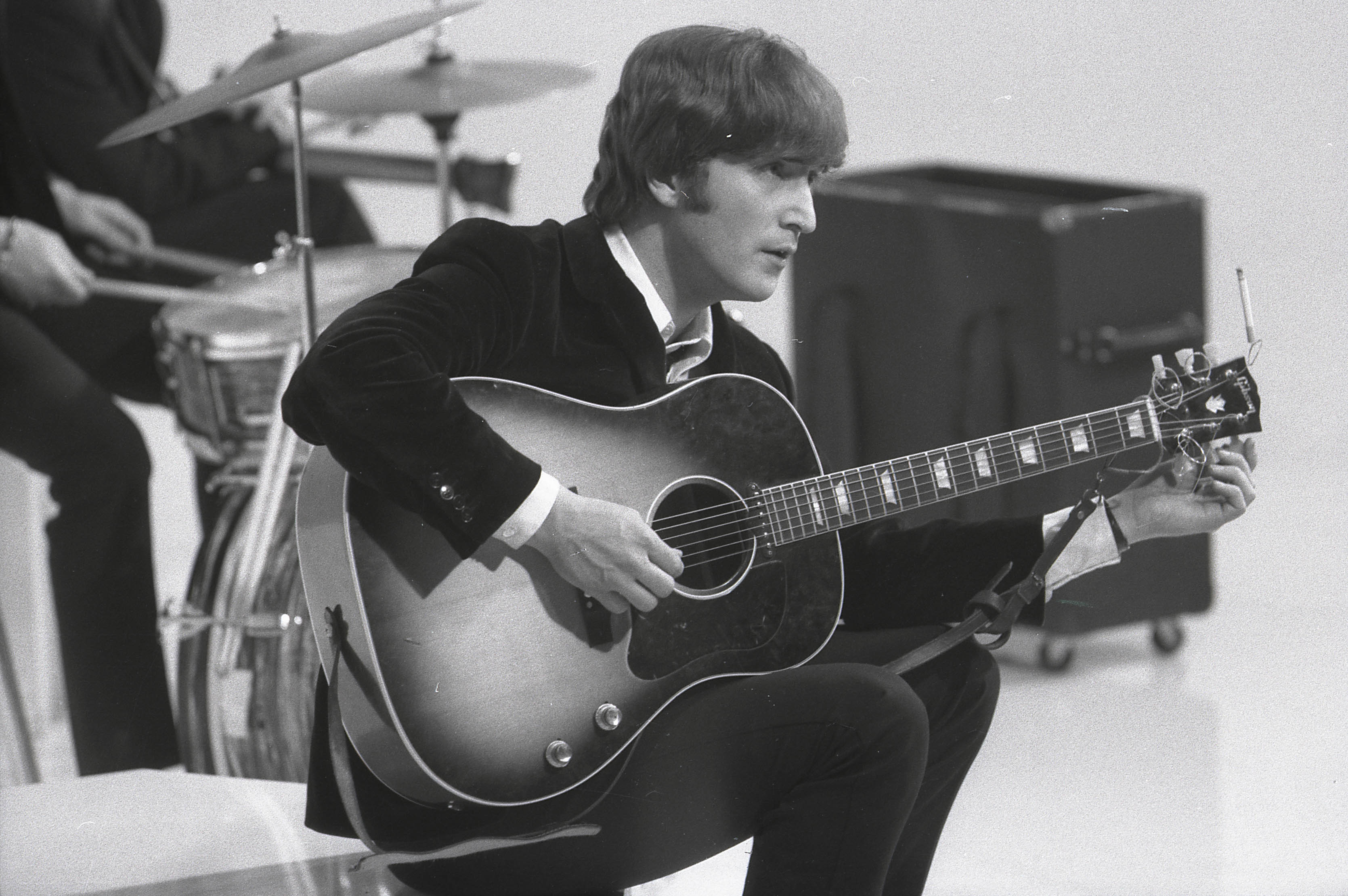 The Beatles' John Lennon holding a guitar during the "In My Life" era