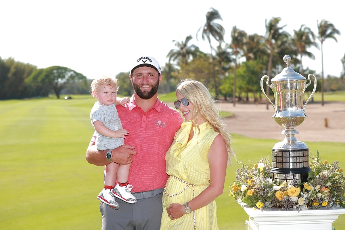 Jon Rahm smiling for a photo with his son, Kepa, and his wife, Kelley Cahill, after winning the Mexico Open at Vidanta 2022