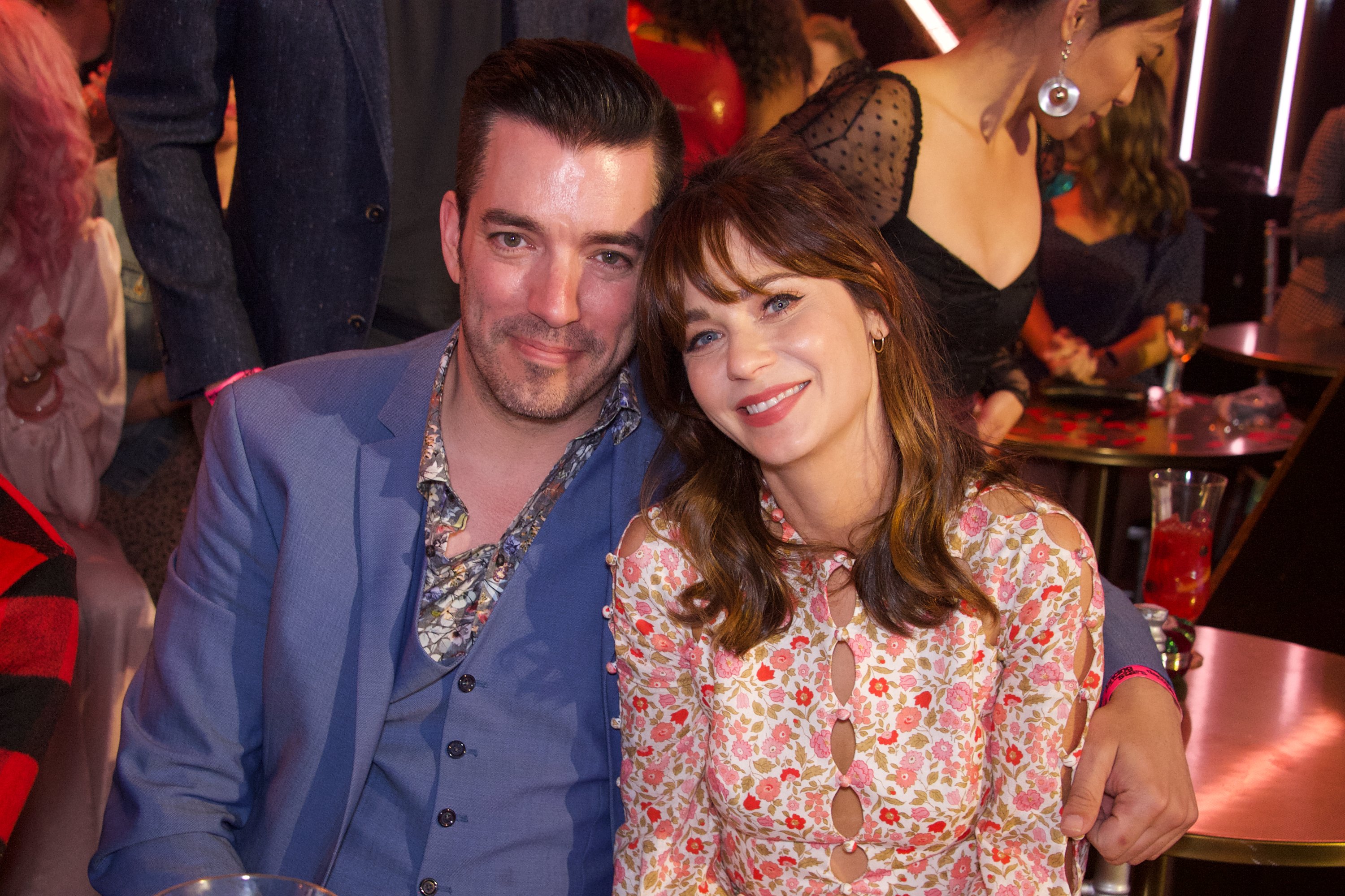 Jonathan Scott and Zooey Deschanel smile during a dinner event. 