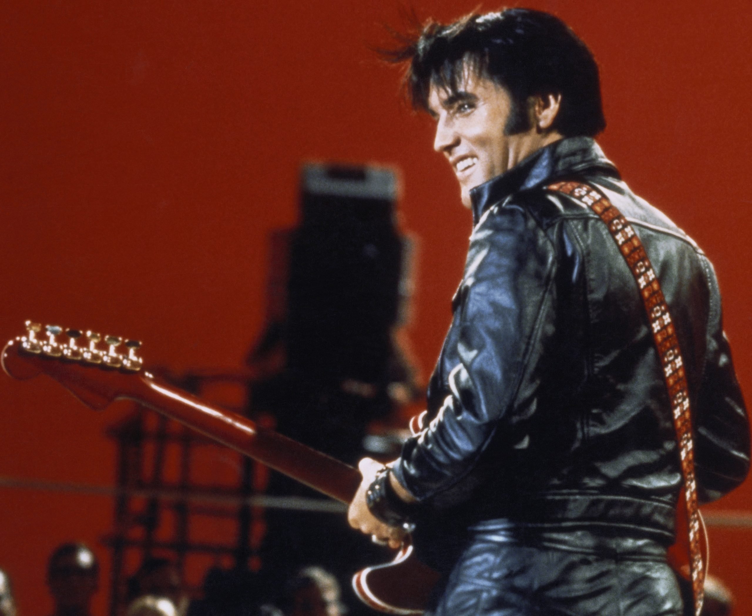 "It's Now or Never" singer Elvis Presley holding a guitar