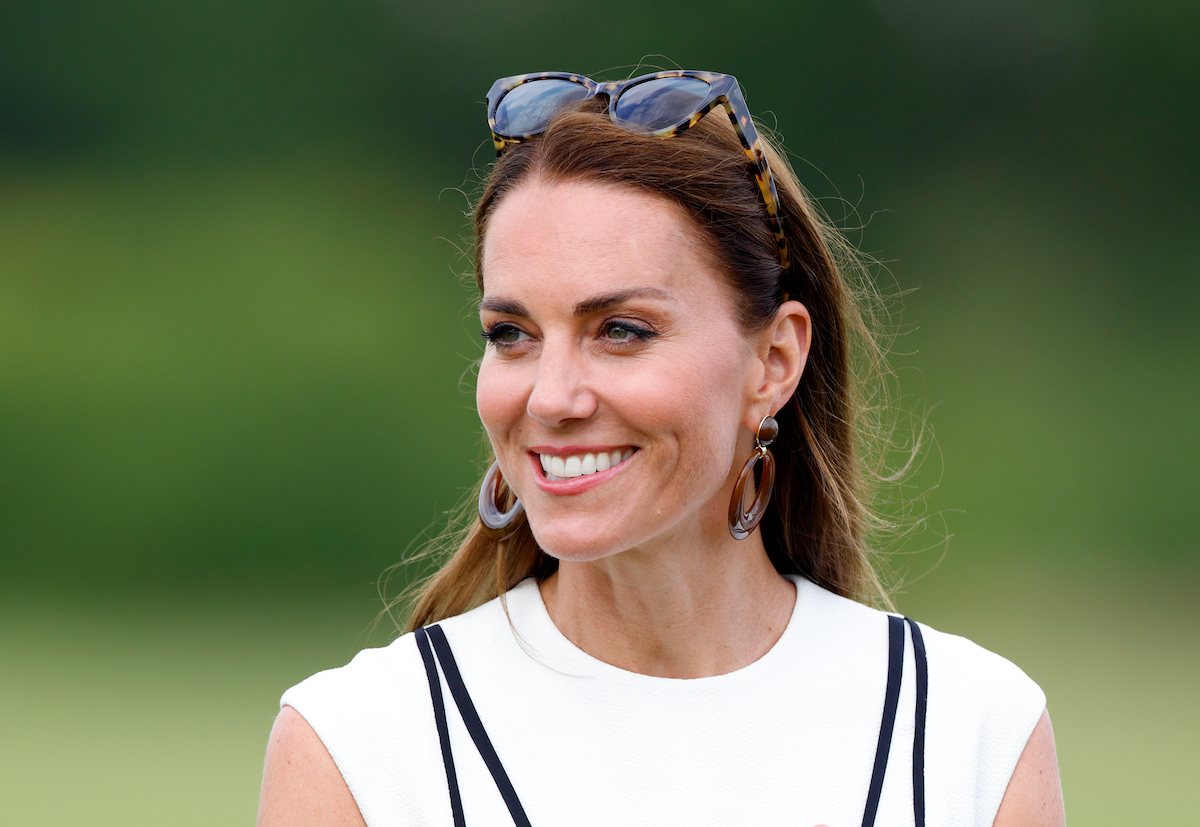 Kate Middleton, whose style helped her cultivate an 'every girl image' according to a commentator, smiles wearing a white dress