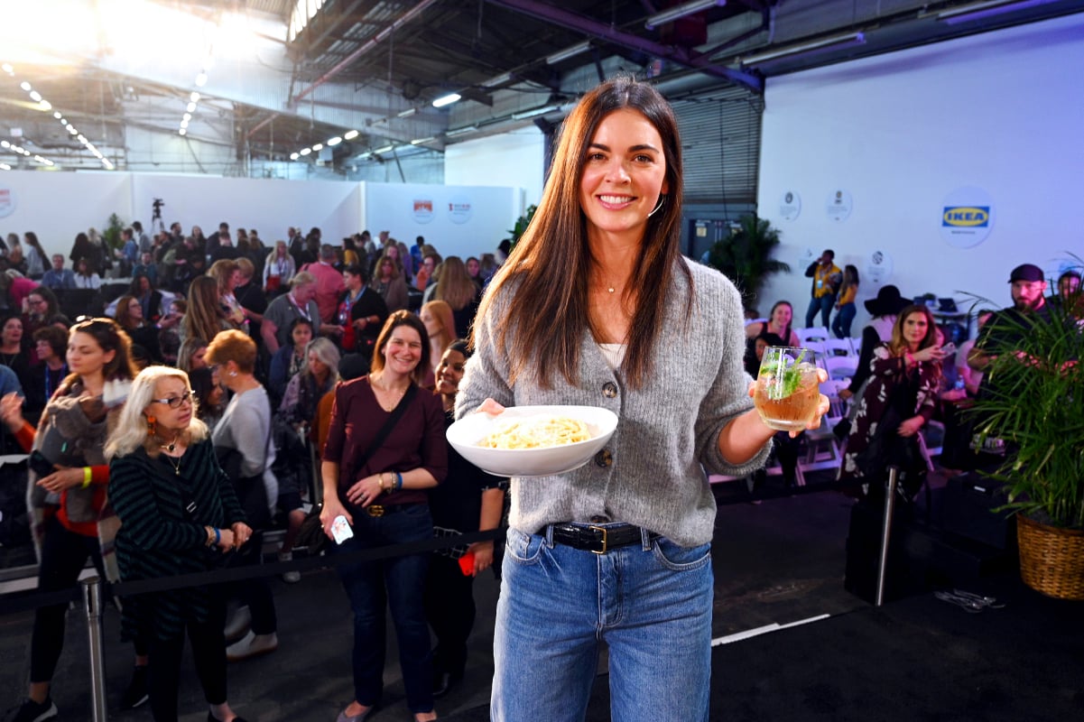 Culinary personality Katie Lee Biegel wears a gray sweater and blue jeans in this photograph.