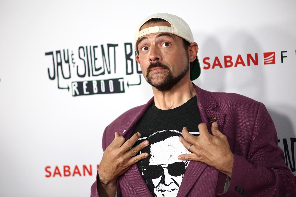 Kevin Smith posing while wearing a purple blazer.