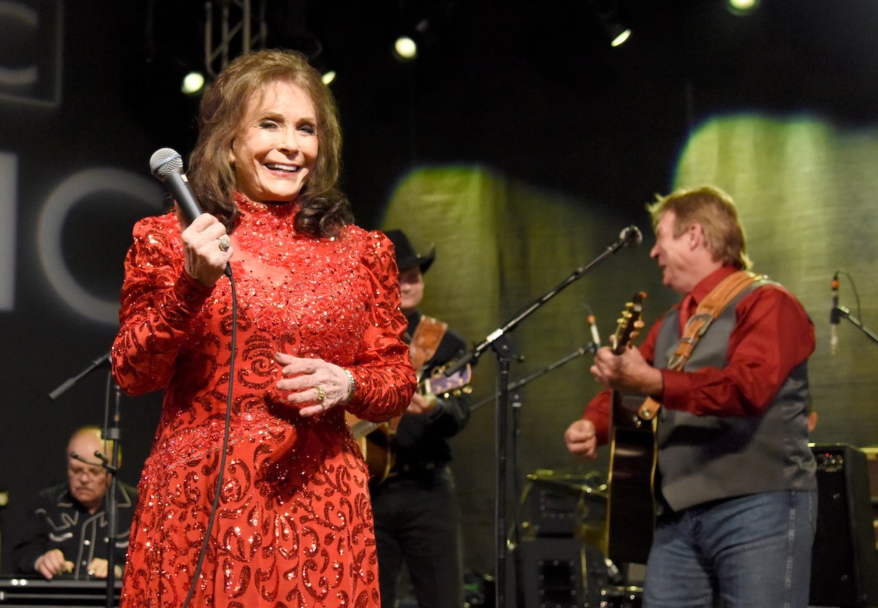 Loretta Lynn, shown in a red ball gown during a 2016 performance, said she and Patsy Cline shared 'girl talk' about their husbands