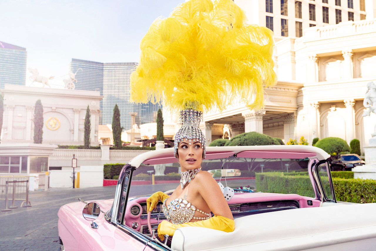 Arielle Vandenberg promoting 'Love Island USA' is in a show girl outfit in a convertible.