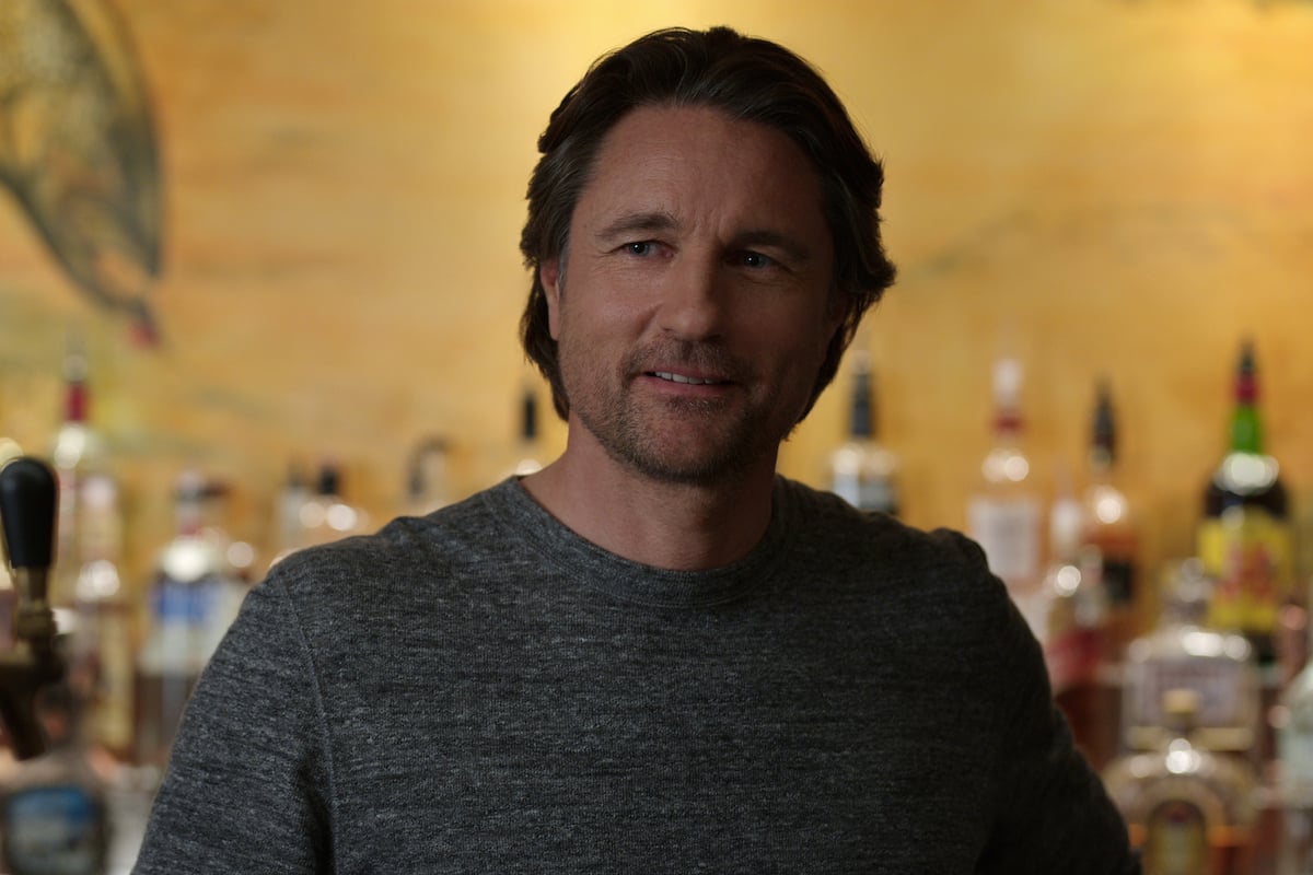 Martin Henderson as Jack Sheridan standing in front of his bar in 'Virgin River'