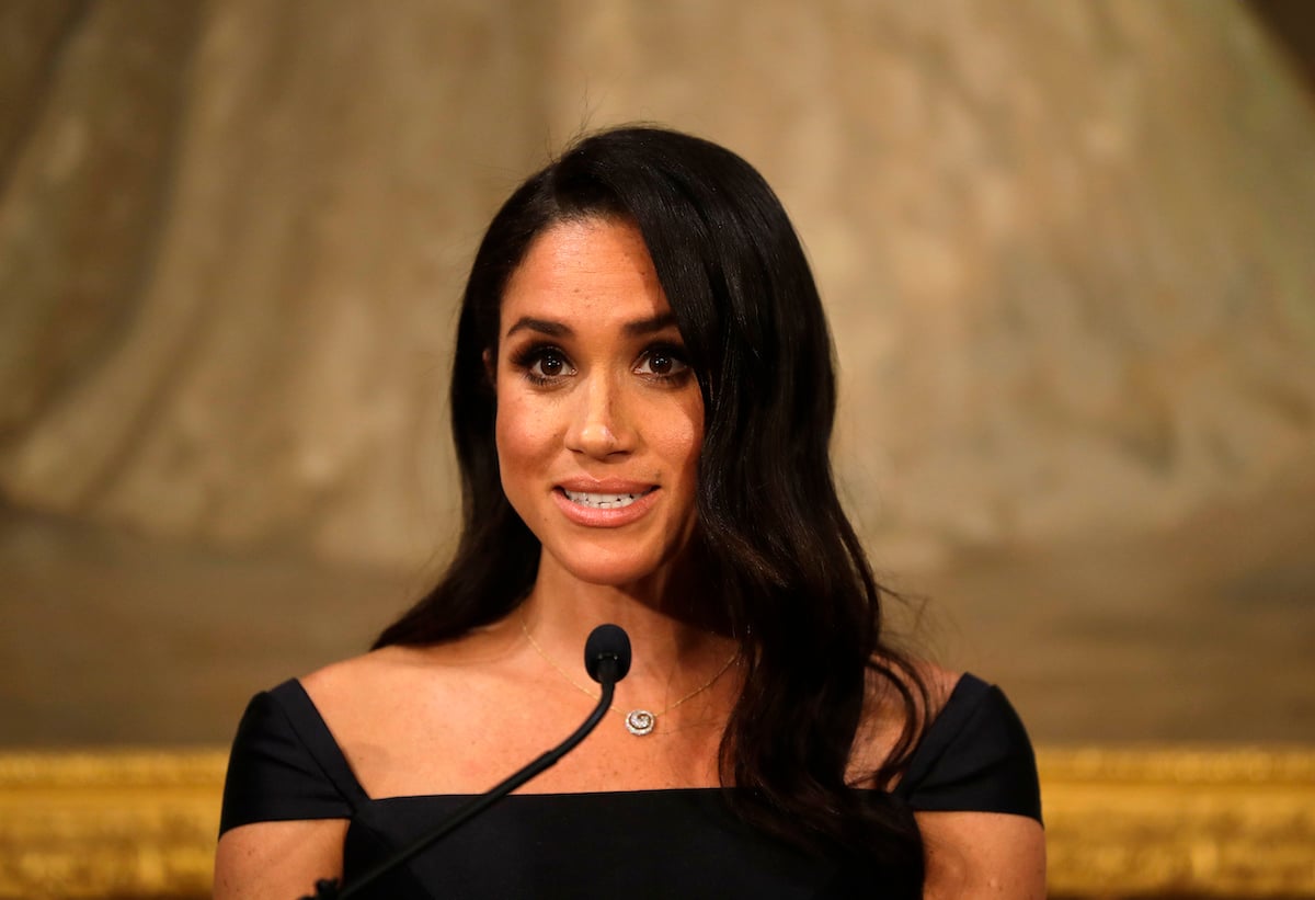 Meghan Markle, who hinted at a trip to Washington, D.C., speaks into a microphone