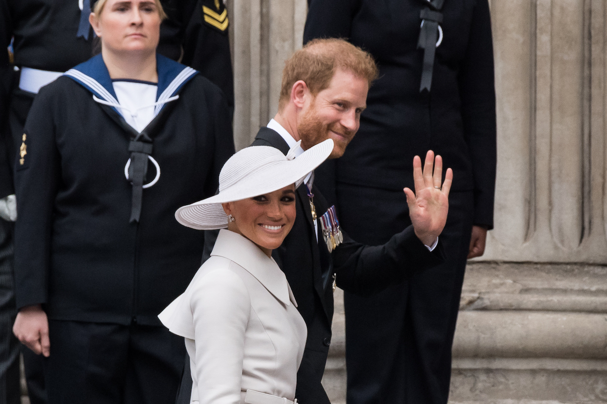 Meghan Markle and Prince Harry, who sat in the second row and, according to Tom Bower, wondered who approved the seats, smile and wave as they enter St. Paul's Cathedral for a national service of thanksgiving