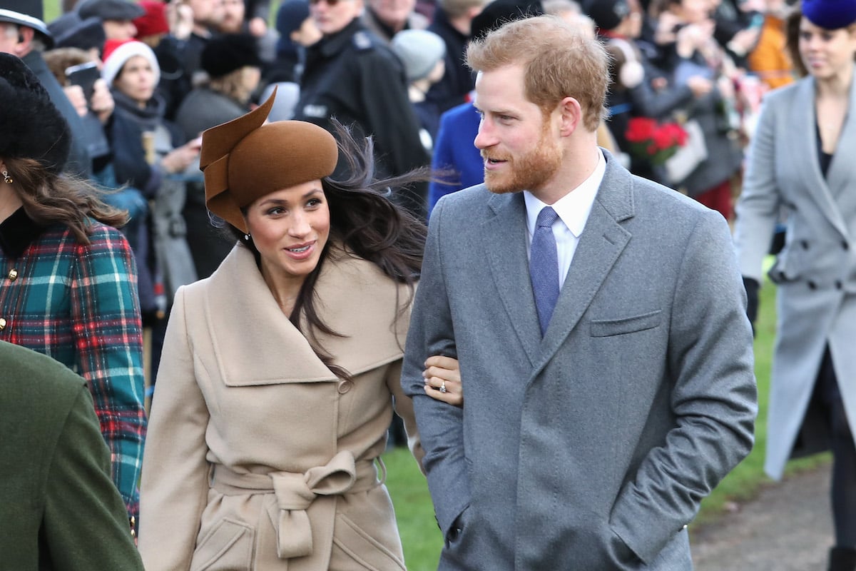 Meghan Markle, who according to Tom Bower researched Prince Harry before they met, walks arm in arm with Prince Harry