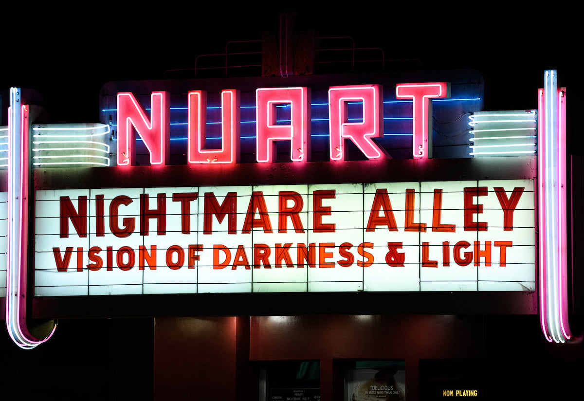 Movie theater marquee with 'Nightmare Alley: Vision Of Darkness And Light' displayed