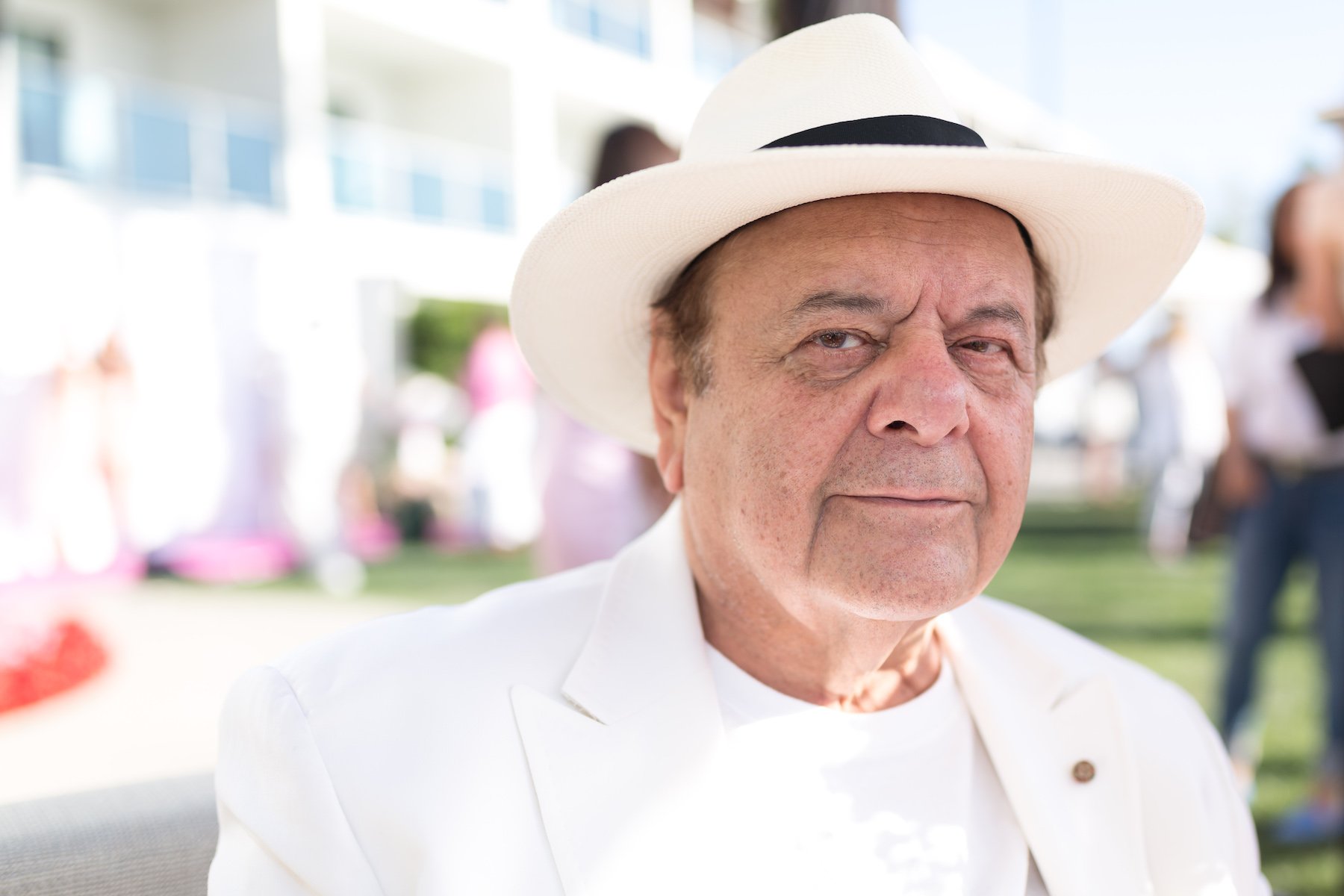 Paul Sorvino wearing all white in a white hat looking at the camera