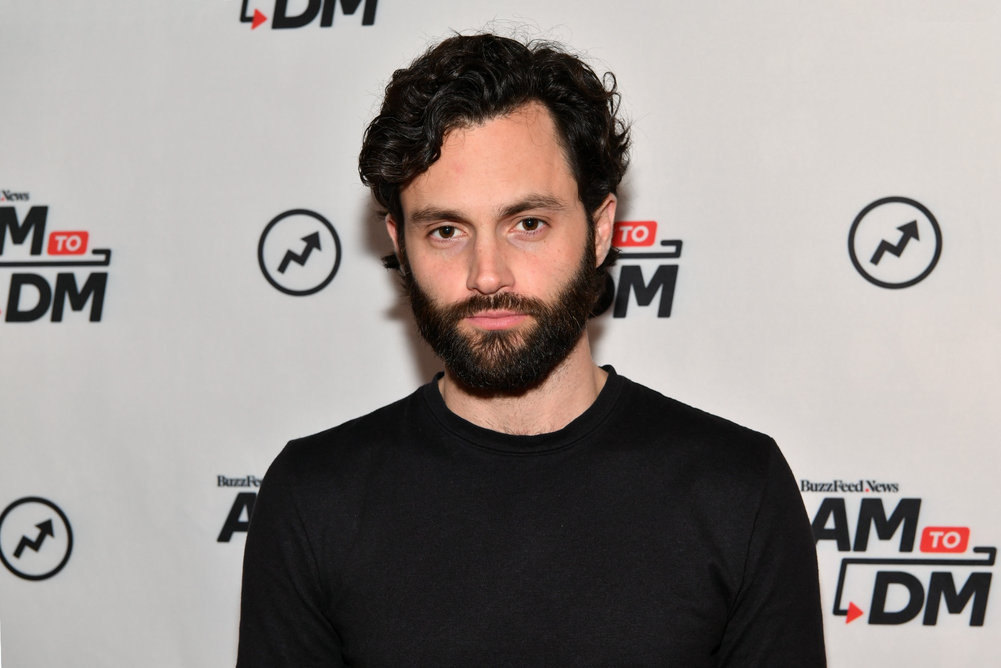 Penn Badgley, who is rumored to be part of 'Fantastic Four' cast. Wearing a black long-sleeve shirt and standing in front of a step and repeat.