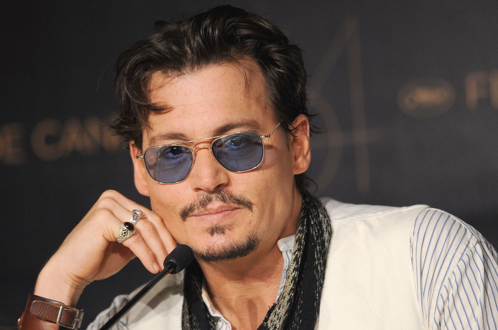 'Pirates of the Caribbean' actor Johnny Depp, who played Captain Jack Sparrow with his hand holding his head up and wearing sunglasses