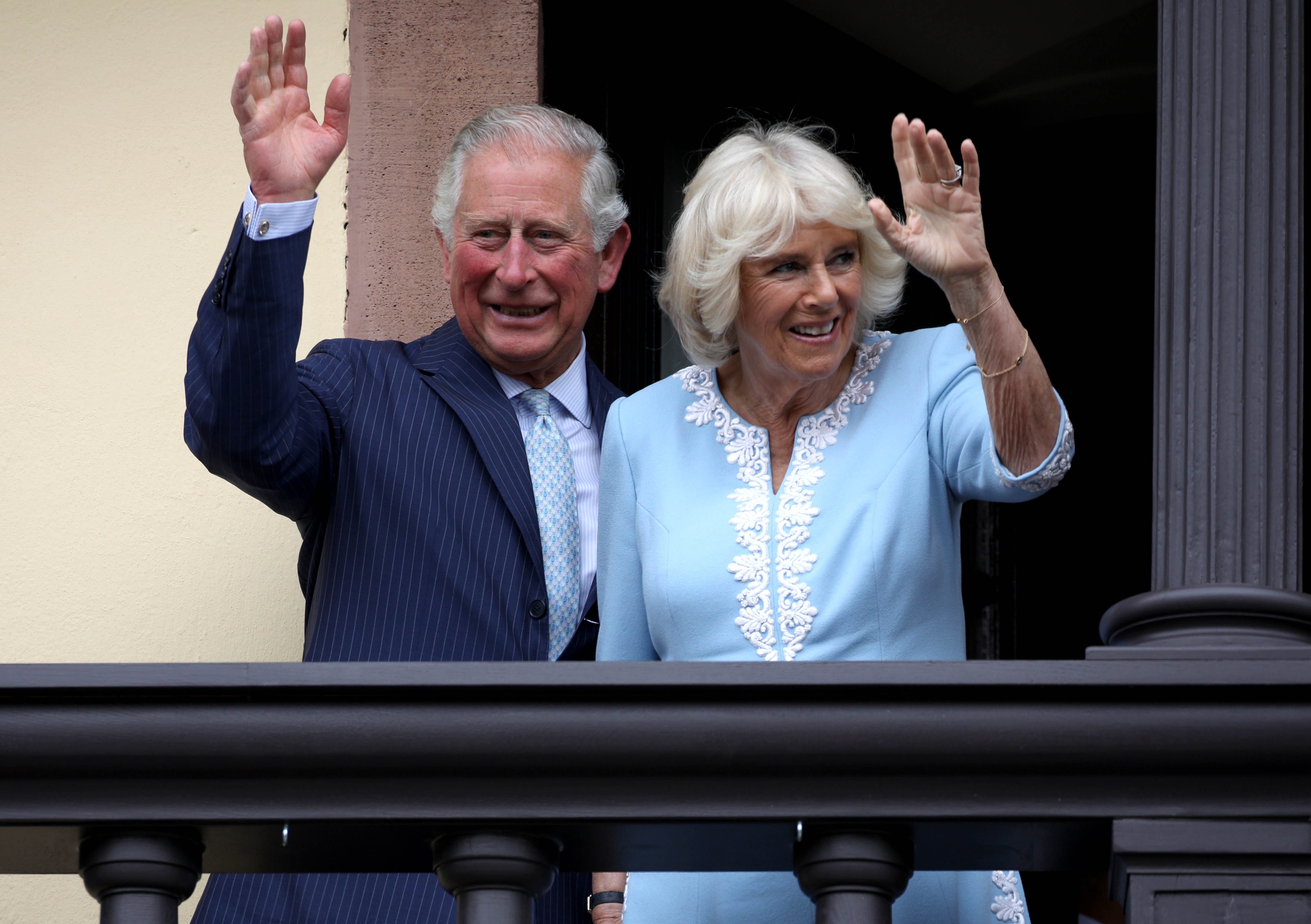 Prince Charles and Camilla Parker Bowles wave to the crowd from the balcony at Old City Hall
