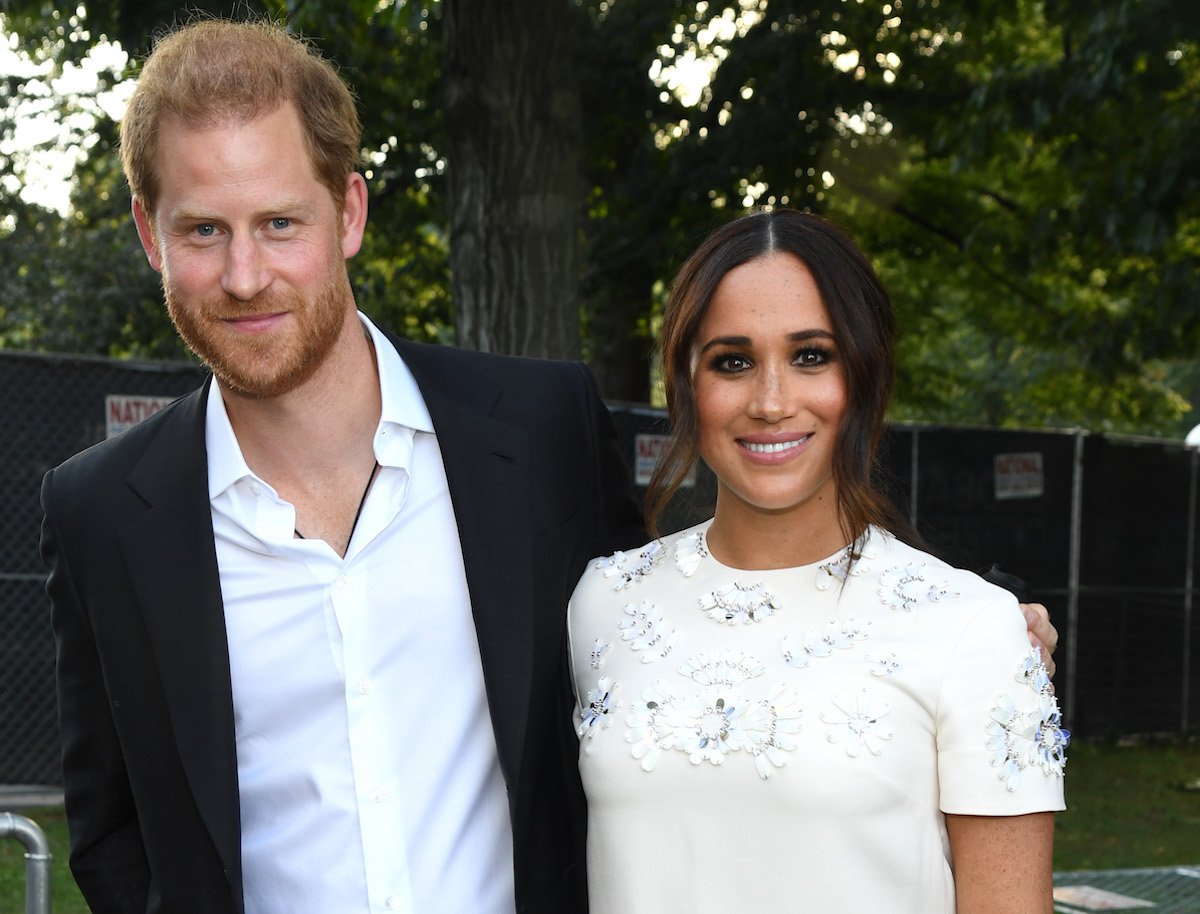 Prince Harry and Meghan Markle, who said her Prince Harry relationship didn't feel like a 'whirlwind,' smile as they stand next to each other