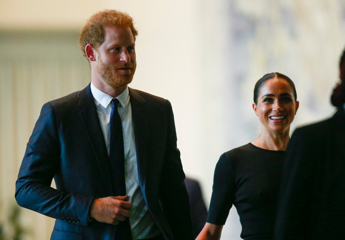 Prince Harry and Meghan Markle, who, according to Tom Bower's 'Revenge' biography, thought Victoria Beckham leaked stories to the press, smiles and look on