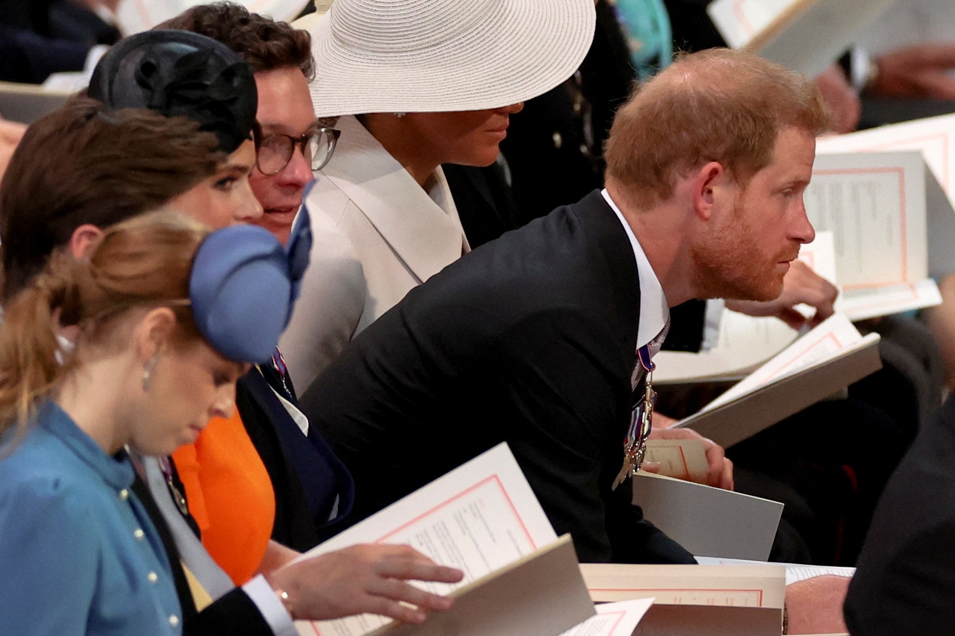 Prince Harry leaning forward in a pew during the National Service of Thanksgiving