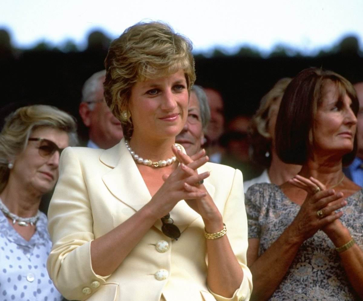 Princess Diana smiling, wearing a pearl necklace