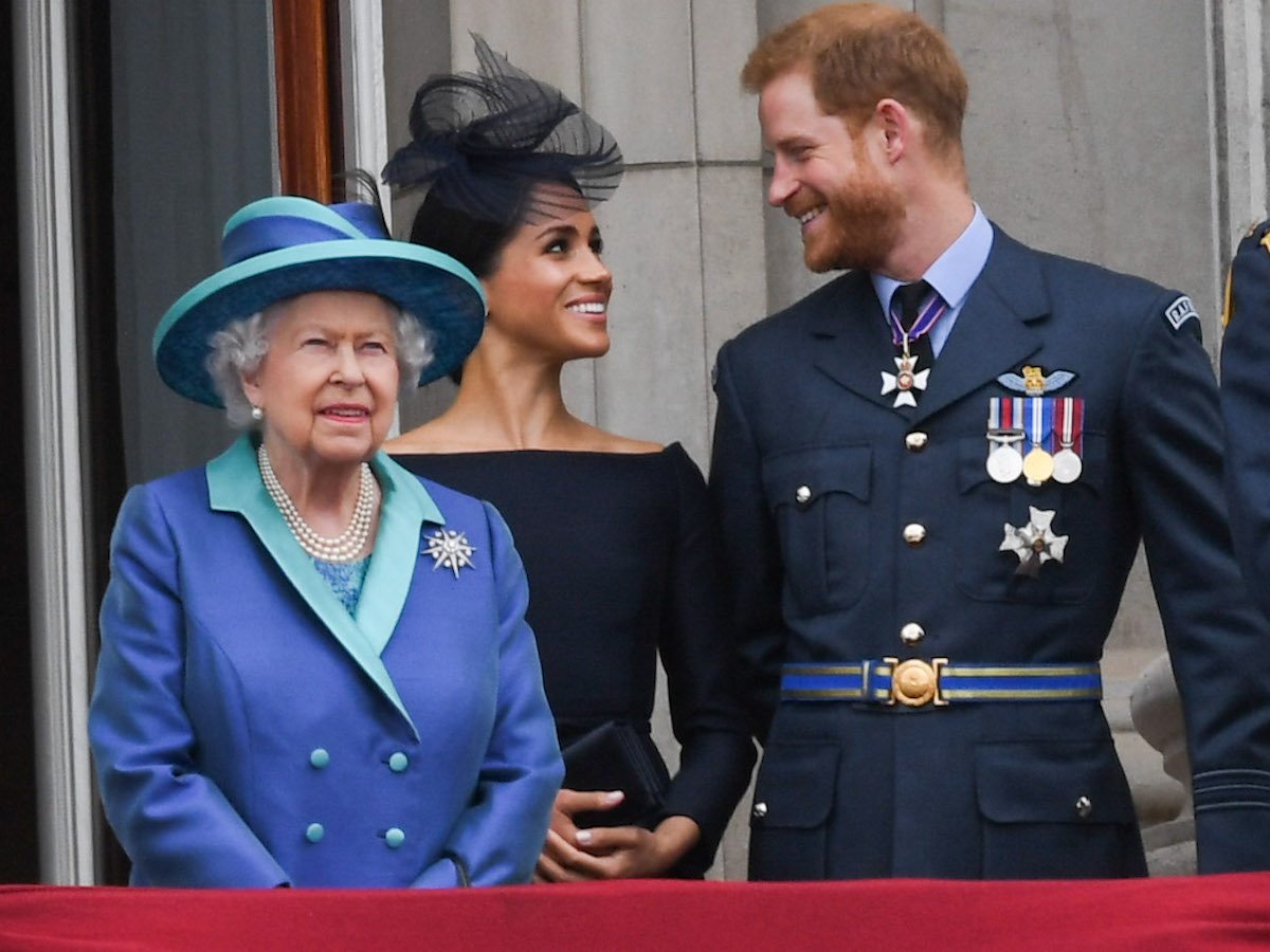 Queen Elizabeth II, who reportedly used to go to Frogmore Cottage to check in on Meghan Markle and Prince Harry, stands with Meghan Markle and Prince Harry