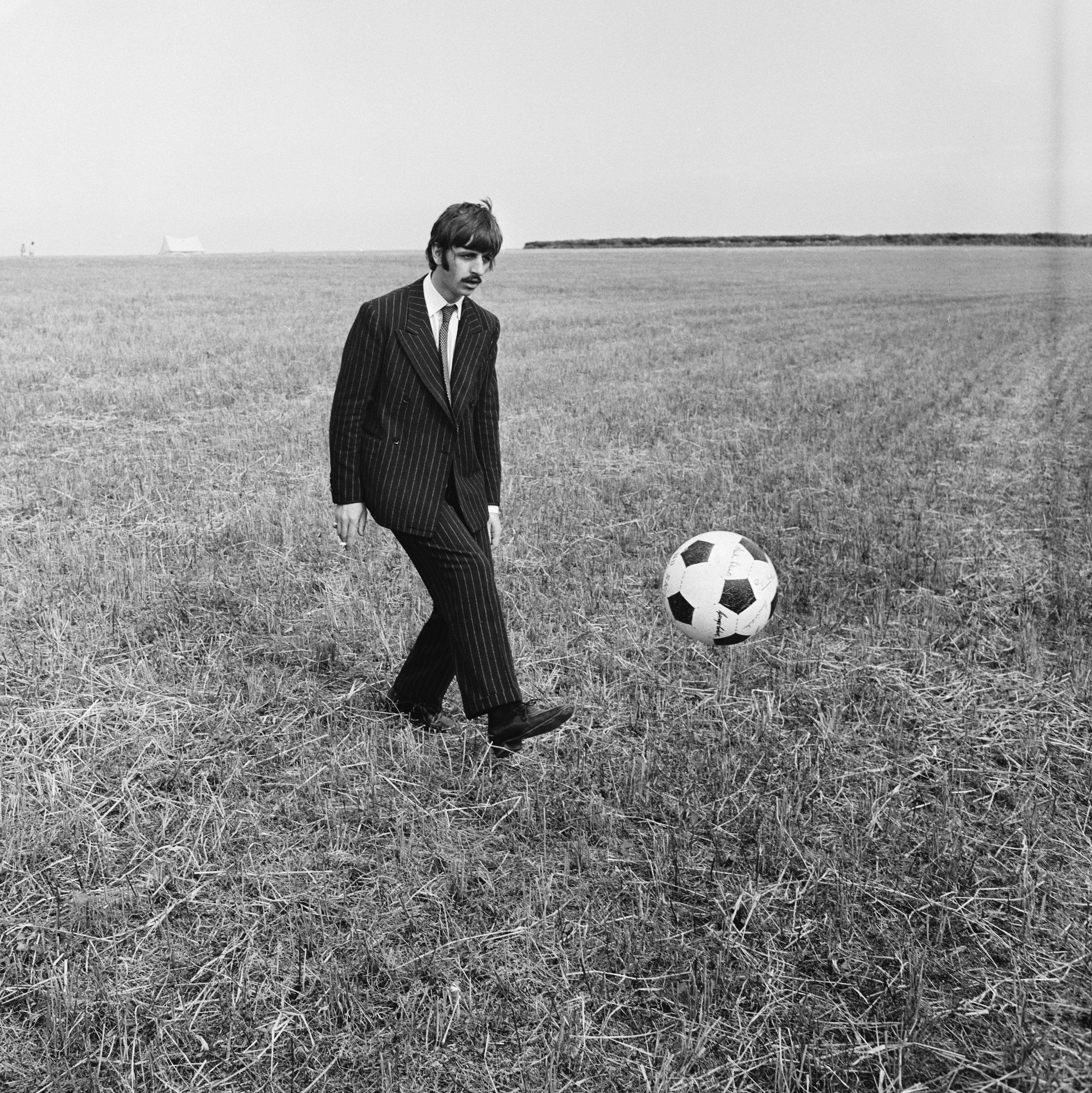 Ringo Starr, drummer with the Beatles, pictured kicking a soccer ball (football) during filming of 'Magical Mystery Tour'