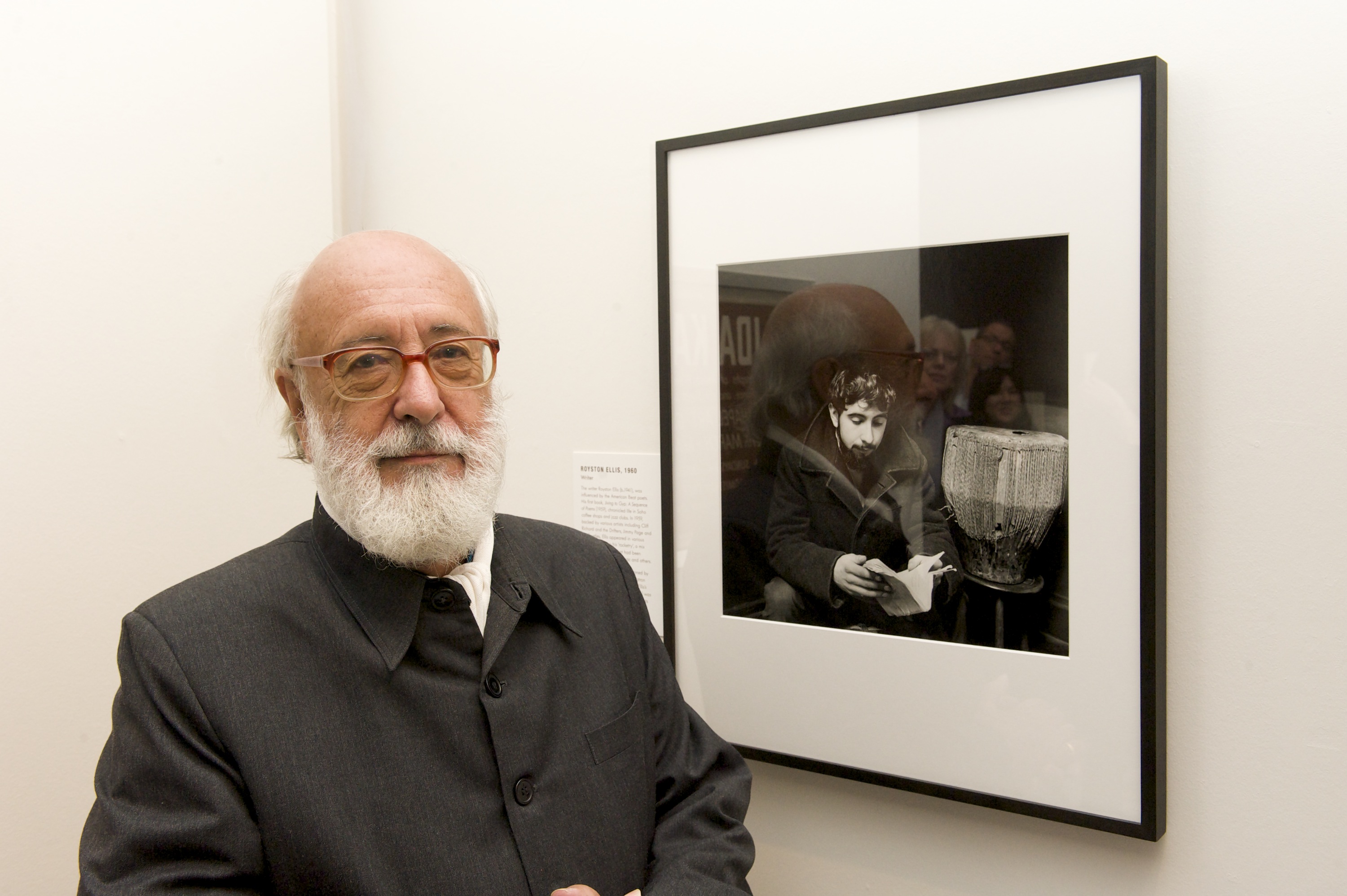 Royston Ellis standing near a photograph