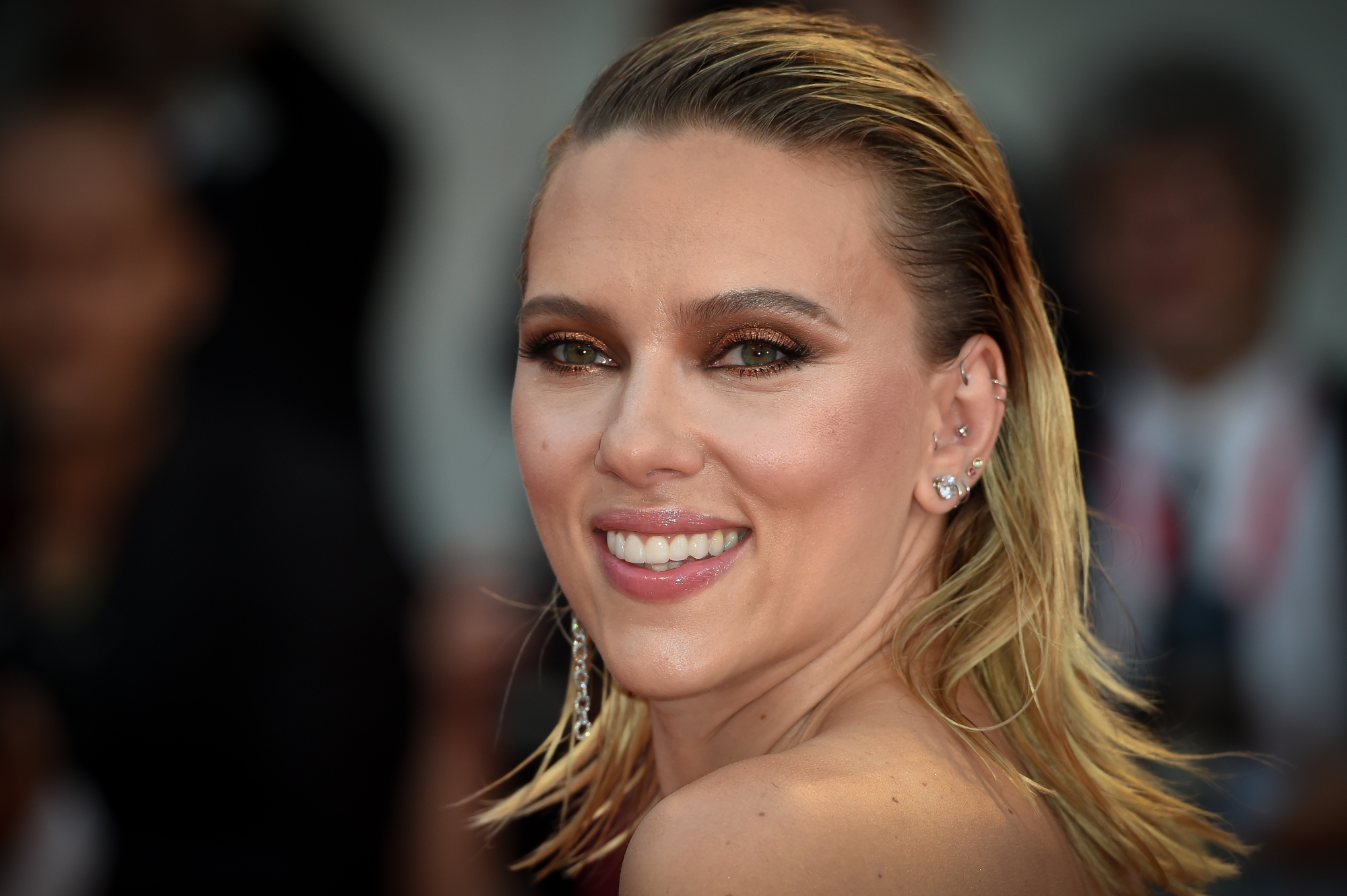 Scarlett Johansson, who was nominated at the Oscars, smiling with ear piercings and slicked back hair