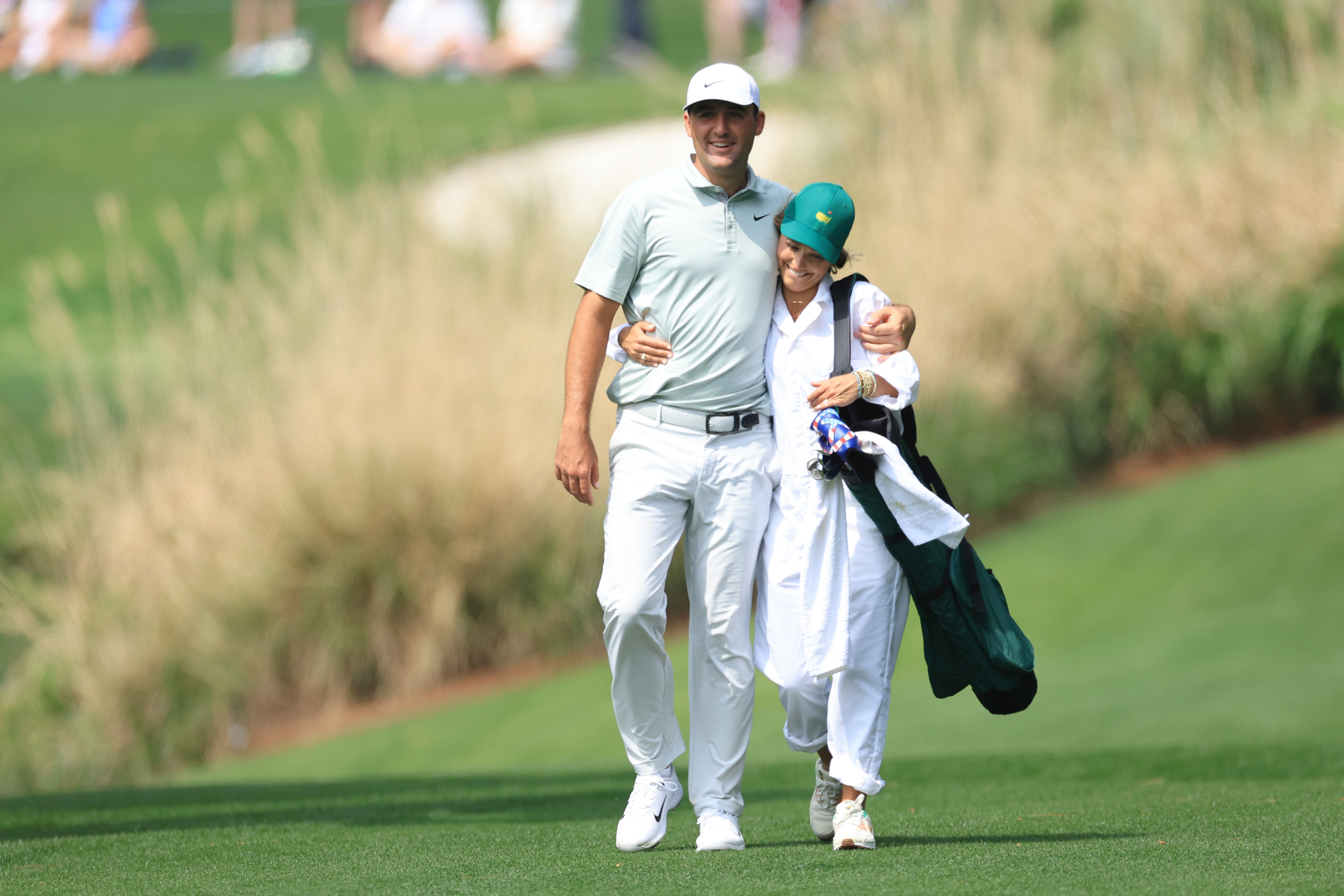 Scottie Scheffler and wife Meredith Scudder walking together during the Par Three Contest prior to the Masters