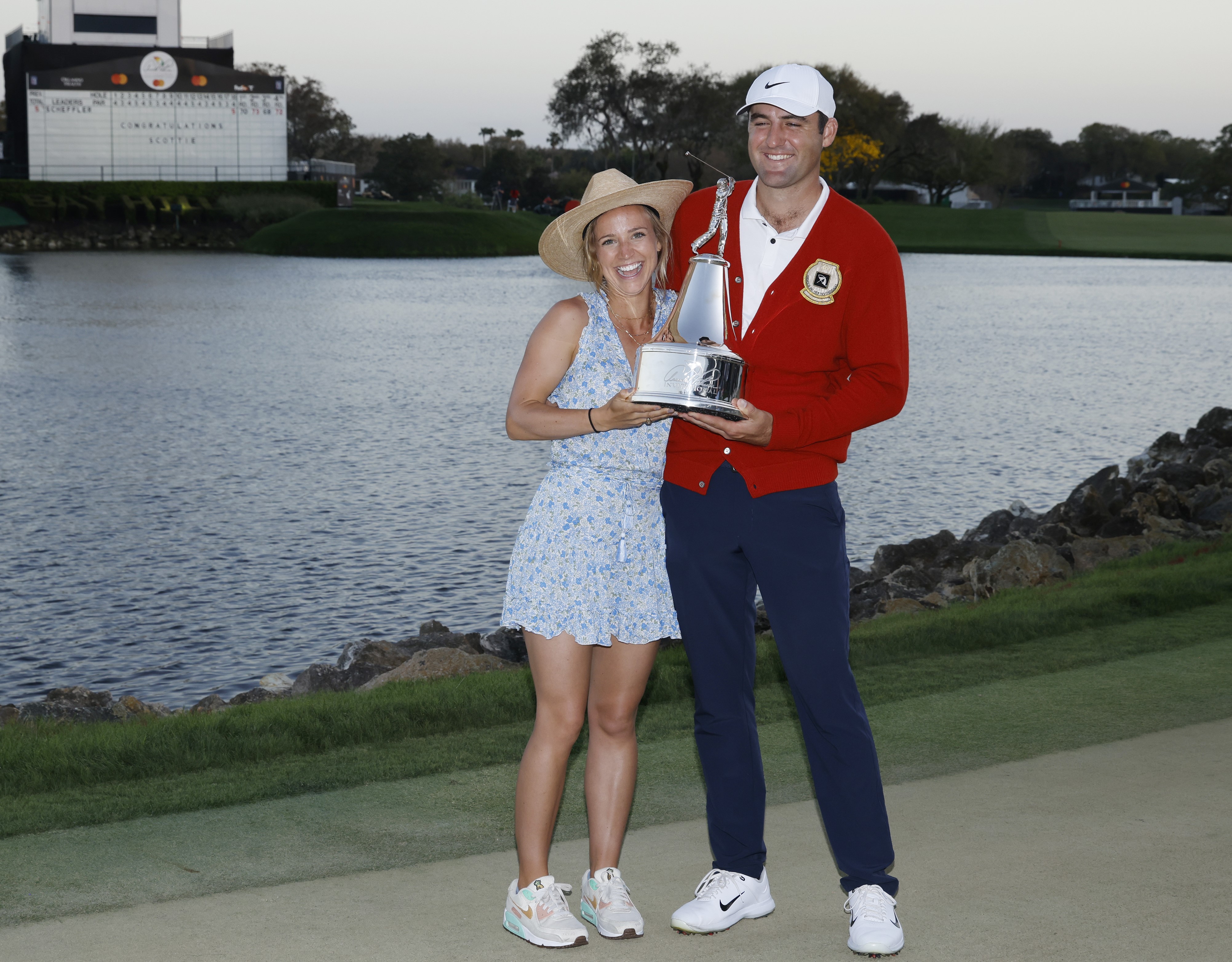 Scottie Scheffler and his wife Meredith Scudder, who he met in high school, holding the trophy after winning the Arnold Palmer Invitational