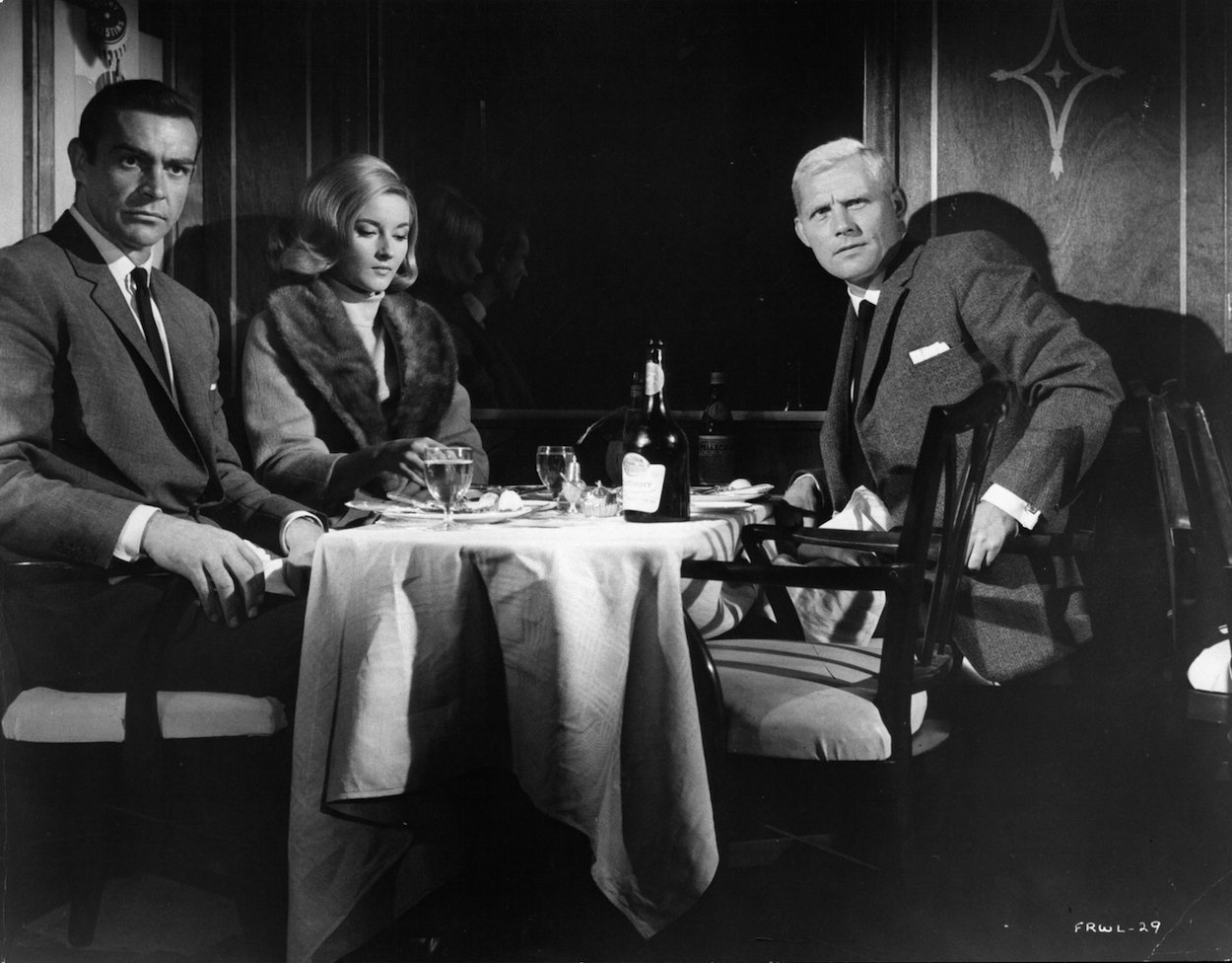 Daniela Bianchi, Sean Connery, and Robert Shaw sitting at a table in the film 'From Russia With Love.' Connery's performance in 'From Russia With Love' was so good, James Bond author Ian Fleming changed the character forever.