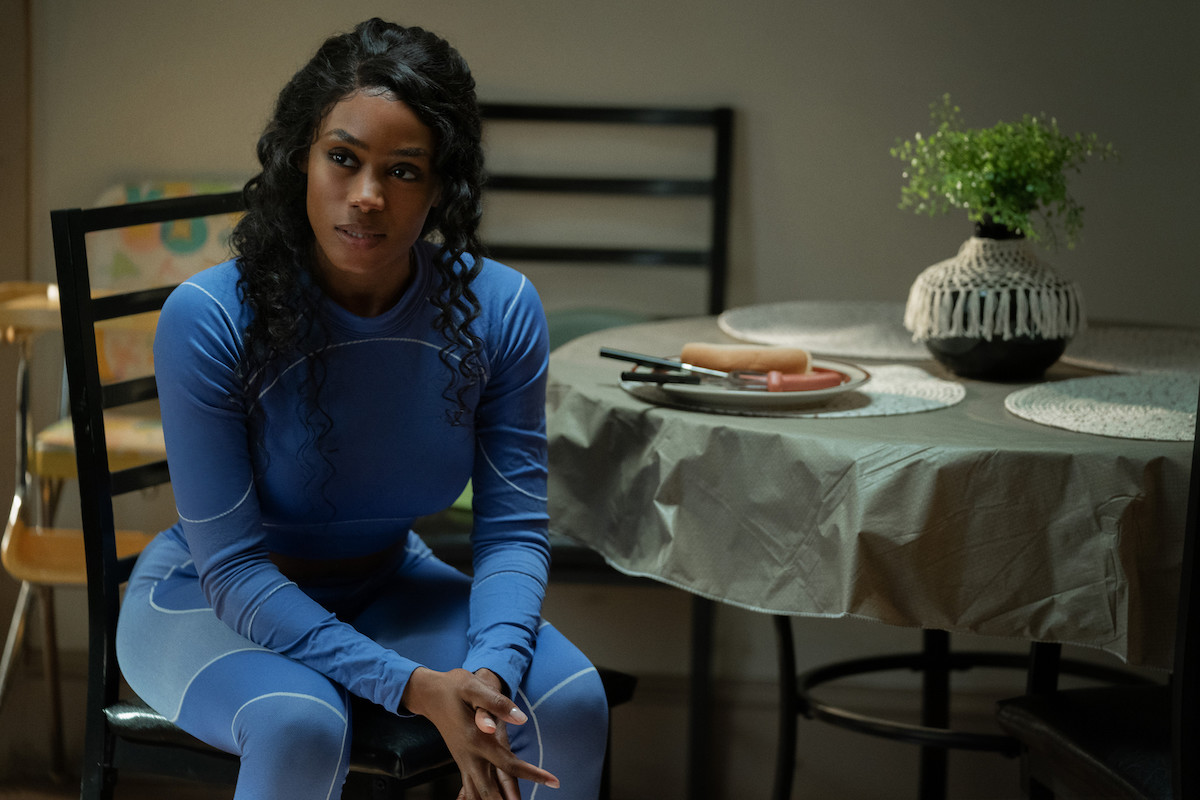 Shannon Thornton as Keyshawn in 'P-Valley' sitting at a table wearing a blue track suit