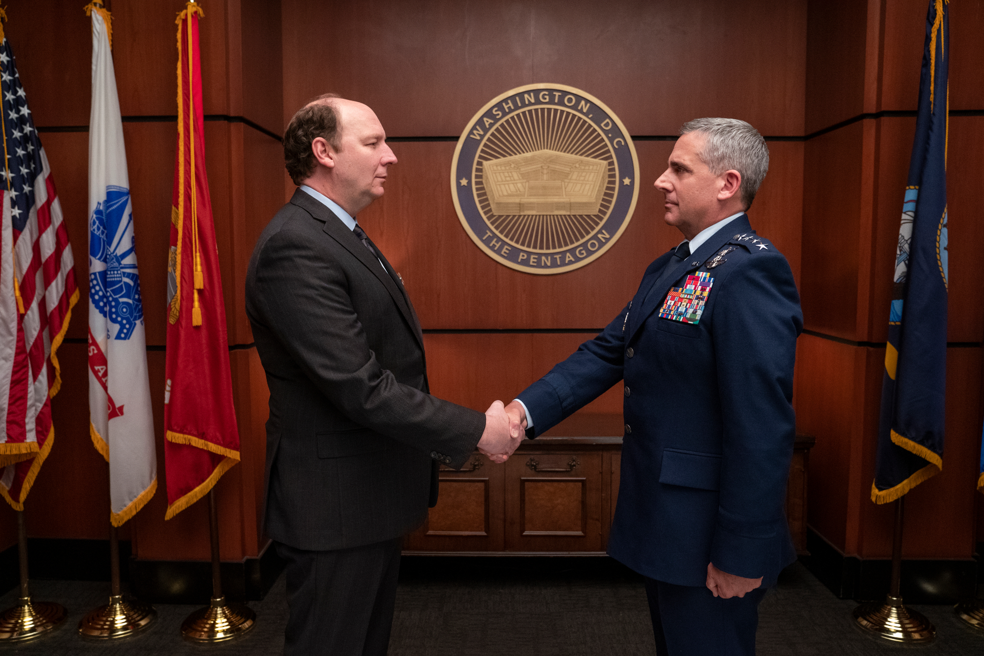 Dan Bakkedahl and Steve Carell in Netflix's 'Space Force' show, which was canceled in 2022. The two are shaking hands.