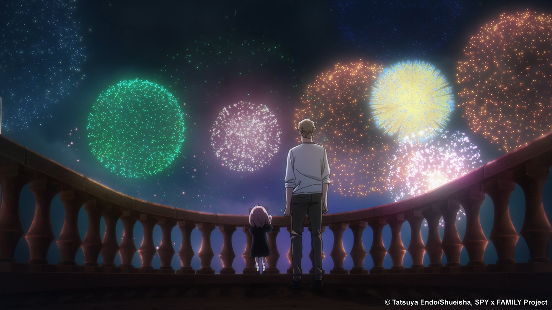 A still from 'Spy x Family' for our list of best anime to watch during summer 2022. It shows Loid and Anya Forger standing next to one another on a balcony and looking out at fireworks.