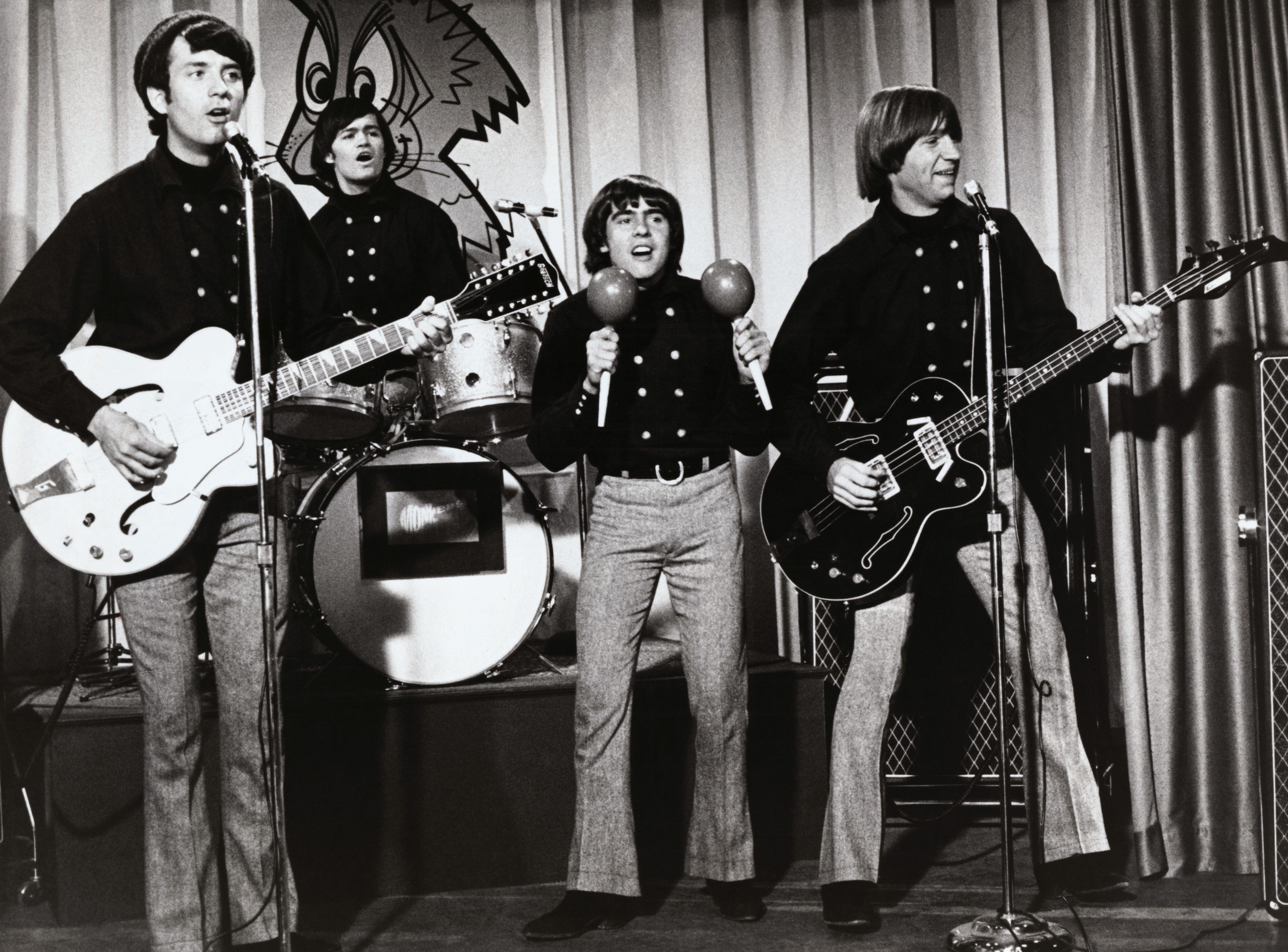 The Monkees' Mike Nesmith, Micky Dolenz, Davy Jones, and Peter Tork playing songs on a stage